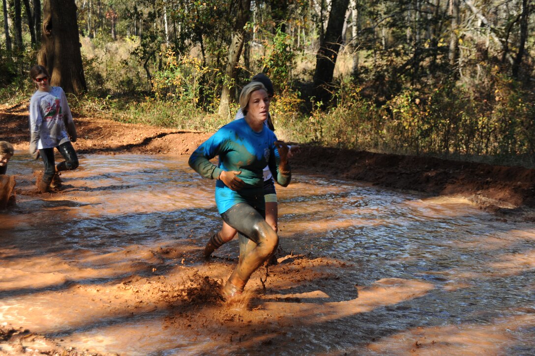 A runner pushes herself through the mud during the Dirty Devil Dog Mud Run at Marine Corps Logistics Base Albany, Nov. 17