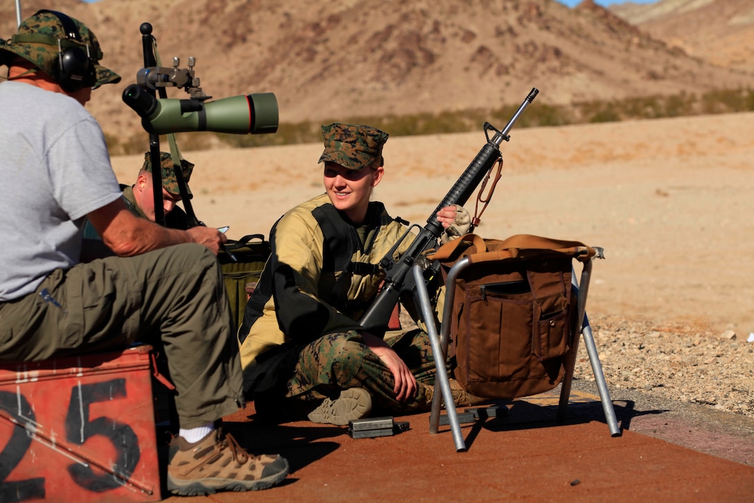 Lance Cpl. Megan R. Difiore (right), 21, a combat videographer for Headquarters and Support Battalion, also a member of the Camp Pendleton shooting team, listens to some words of advice from an advanced shooter during the National Rifle Association Match at the known-distance range here Nov. 17.