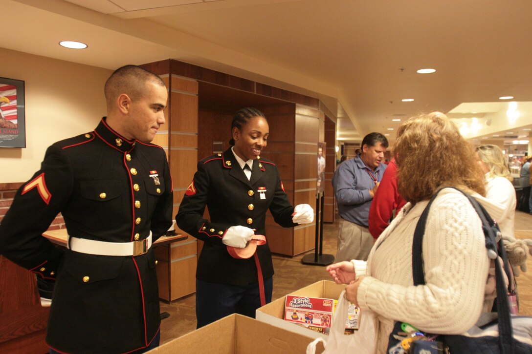 Pfc. Frank Natal, left, and Lance Cpl. Autumn Williams, from the Center for Naval Aviation Technical Training Marine Unit Cherry Point, receive Toys for Tots donations at the Guitar Pull concert Nov. 14. The donation boxes were emptied multiple times throughout the night due to the high number of donations of toys like footballs, dolls and art projects. Tickets were entered into a drawing to win a guitar signed by concert performers.

