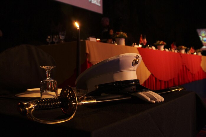 An inverted place setting along with a barracks cover, noncommissioned officer's sword and gloves rest upon the fallen comrades table at the IronWorks Gym here Nov. 8,2012. During Marine Corps ceremonies it is a tradition to set an empty place for fallen Marines in recognition of their ultimate sacrifice.
