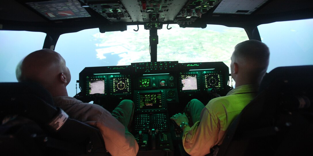 Gunnery Sgt. Andrew Bauer, left, and Maj. John P. Arnold pilot an MV-22 Containerized Flight Training Device at Marine Corps Air Station Futenma recently. Arnold is the officer in charge of Marine Aviation Training Systems Site Futenma. Bauer is the site's staff noncommissioned officer in charge.
