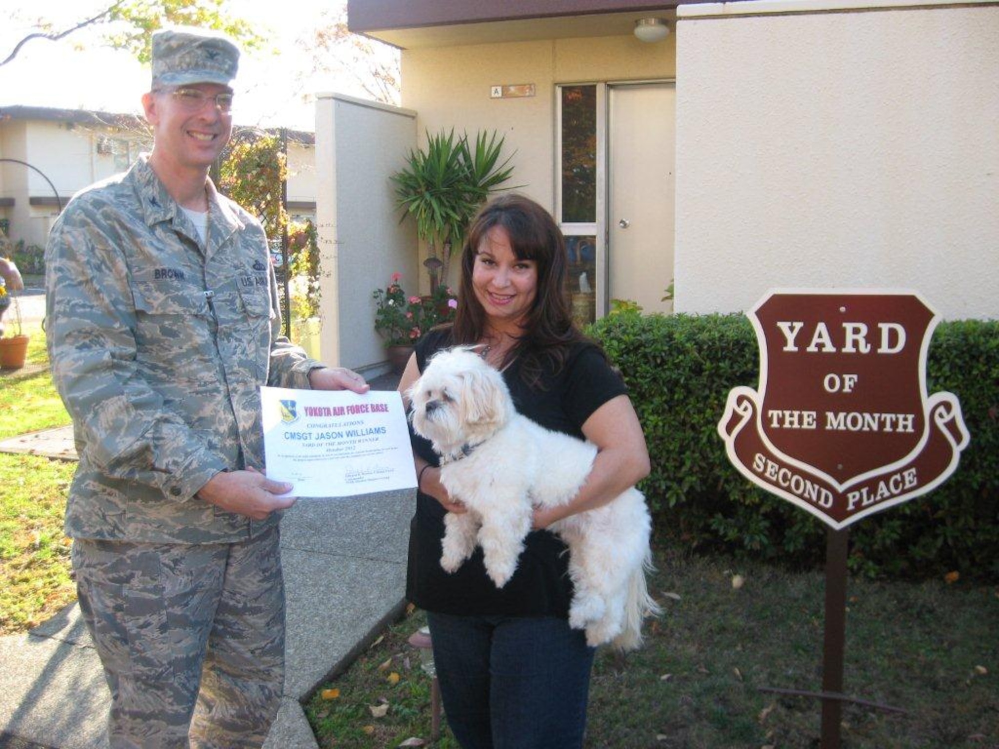 YOKOTA AIR BASE, Japan -- Col. Edward Brown, left, 374th Mission Support Group commander, presents a certificate to Lisa Williams, wife of Chief Master Sgt. Jason Williams, congratulating her on winning 2nd place in the new Yard of the Month program at Yokota Air Base, Japan. (Courtesy photo from the 374th Civil Engineer Squadron)