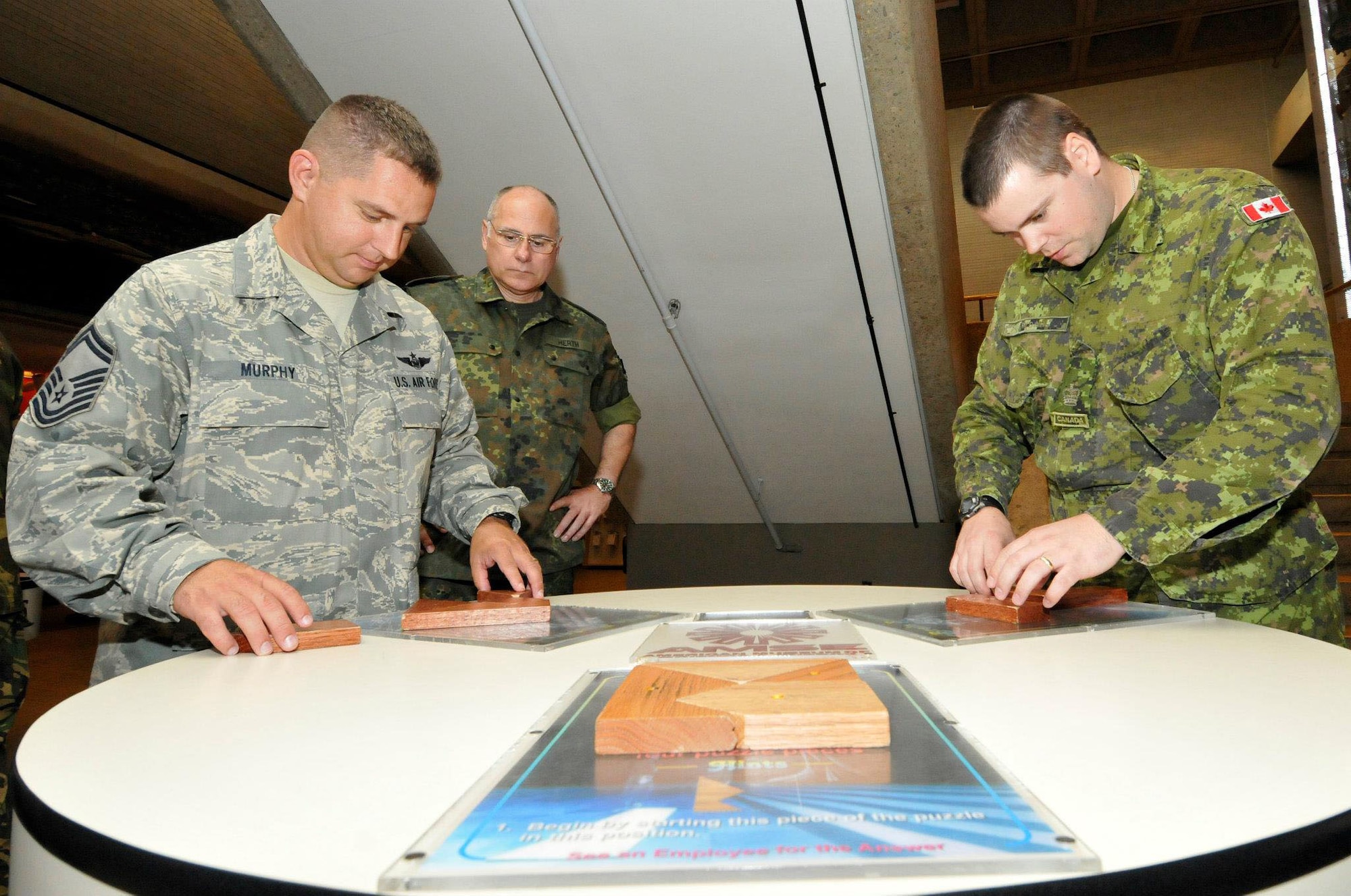 Senior Master Sgt. Mike Murphy, left, a flight engineer in the 166th Airlift Wing, Delaware Air National Guard, works on a puzzle with a fellow NATO service member from Canada during the International NCO Leadership Development Symposium (INLEAD) held July 8-13, 2012 at the Air National Guard Training and Education Center, McGhee-Tyson ANG Base, Tenn. (National Guard photo)