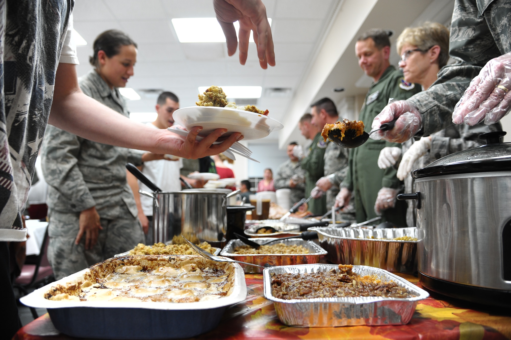 Airmen grab platefuls of hot food during the 2012 Dormsgiving Nov. 15 in the Chapel Annex.  Dormsgiving is a Thanksgiving-themed Dorm Dinner that gives enlisted Airmen that live in the dormitories a chance to eat a hot meal.  (U.S. Air Force Photo/Airman 1st Class Charles Dickens)