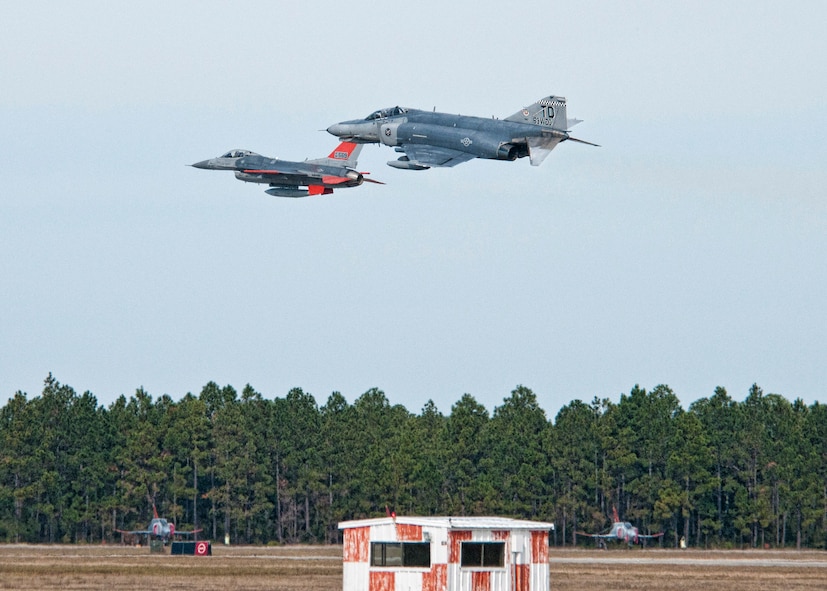 The first QF-16 arrives at Tyndall escorted by a QF-4 Nov. 19. The QF-16 will undergo developmental testing by Boeing and eventually become part of the 53rd Weapons Evaluation Group. The QF-16 is a supersonic reusable full-scale aerial target drone modified from an F-16 Fighting Falcon. At this time, the group uses QF-4s, made from 1960s F-4 Phantom, to conduct their full-scale aerial target missions. The targets allow the Air Force and allied nations to have a realistic understanding of what they could face on the battlefield. (U.S. Air Force photo by Chris Cokeing)