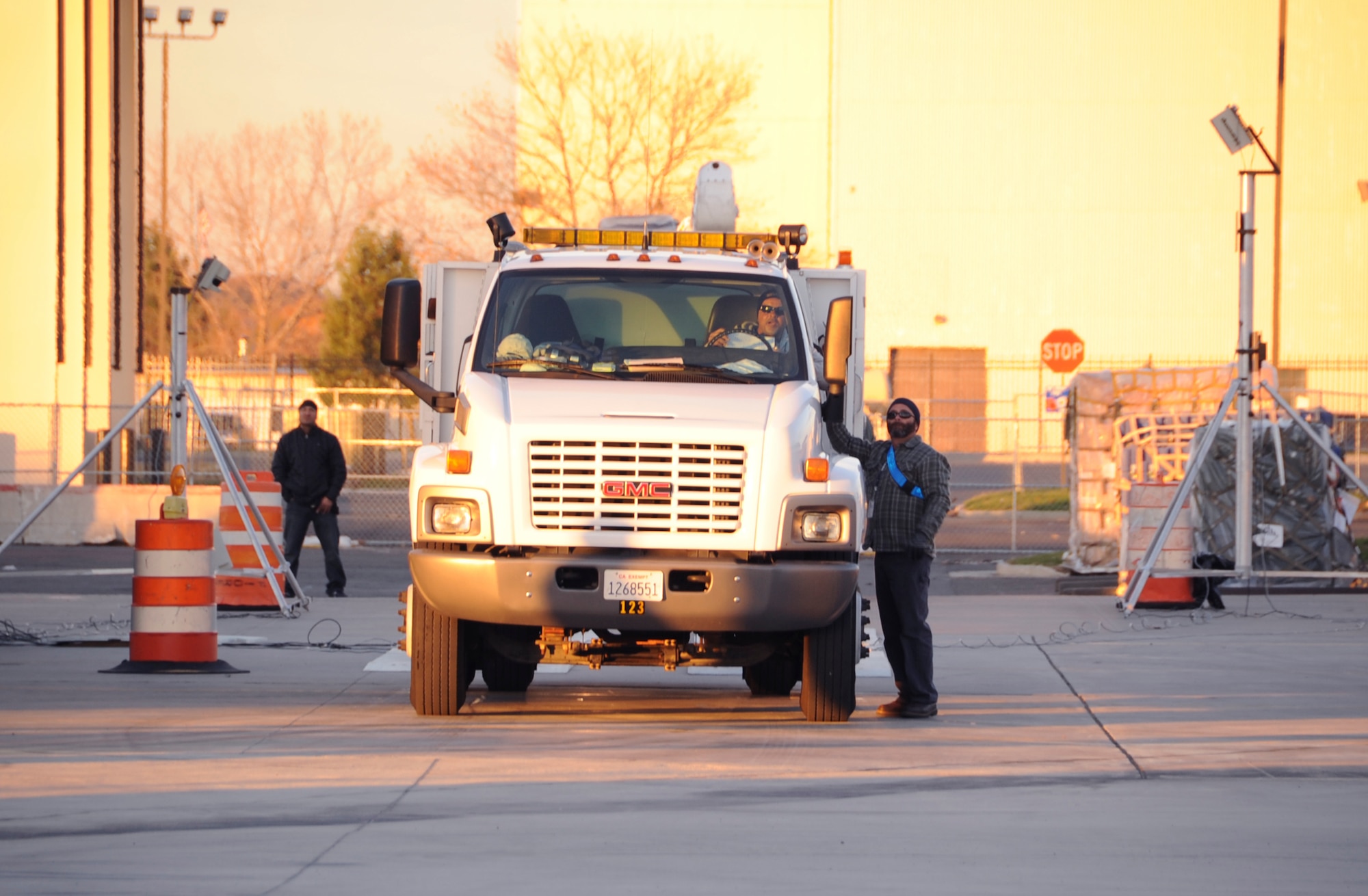 Timothy Jones, 305th Aerial Port Squadron aerial transportation specialist, talks with the power line truck operator to describe where he should stage his vehicle Nov. 16, 2012, at Joint Base McGuire-Dix-Lakehurst, N.J. The power line trucks will be flown back to California after they were used in hurricane-relief efforts. (U.S. Air Force photo by Staff Sgt. David Carbajal/Released)
