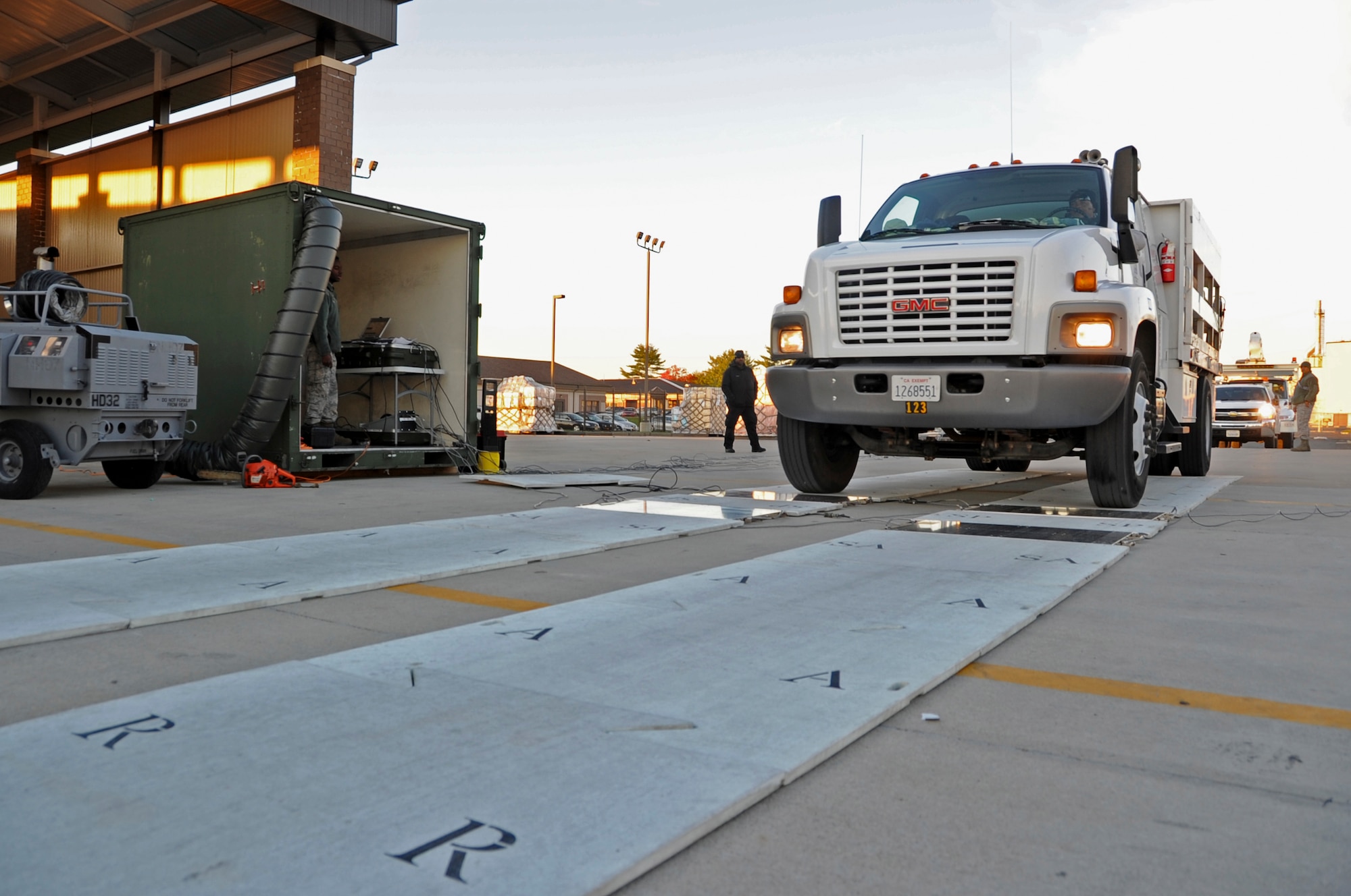 A utility and line truck drives through a Deployable Automated Cargo Measurement System Nov. 16, 2012, at Joint Base McGuire-Dix-Lakehurst, N.J., to determine if the truck’s approximate size and weight. The utility and line trucks were flown back to California after they were used in hurricane-relief efforts. (U.S. Air Force photo by Staff Sgt. David Carbajal/Released)