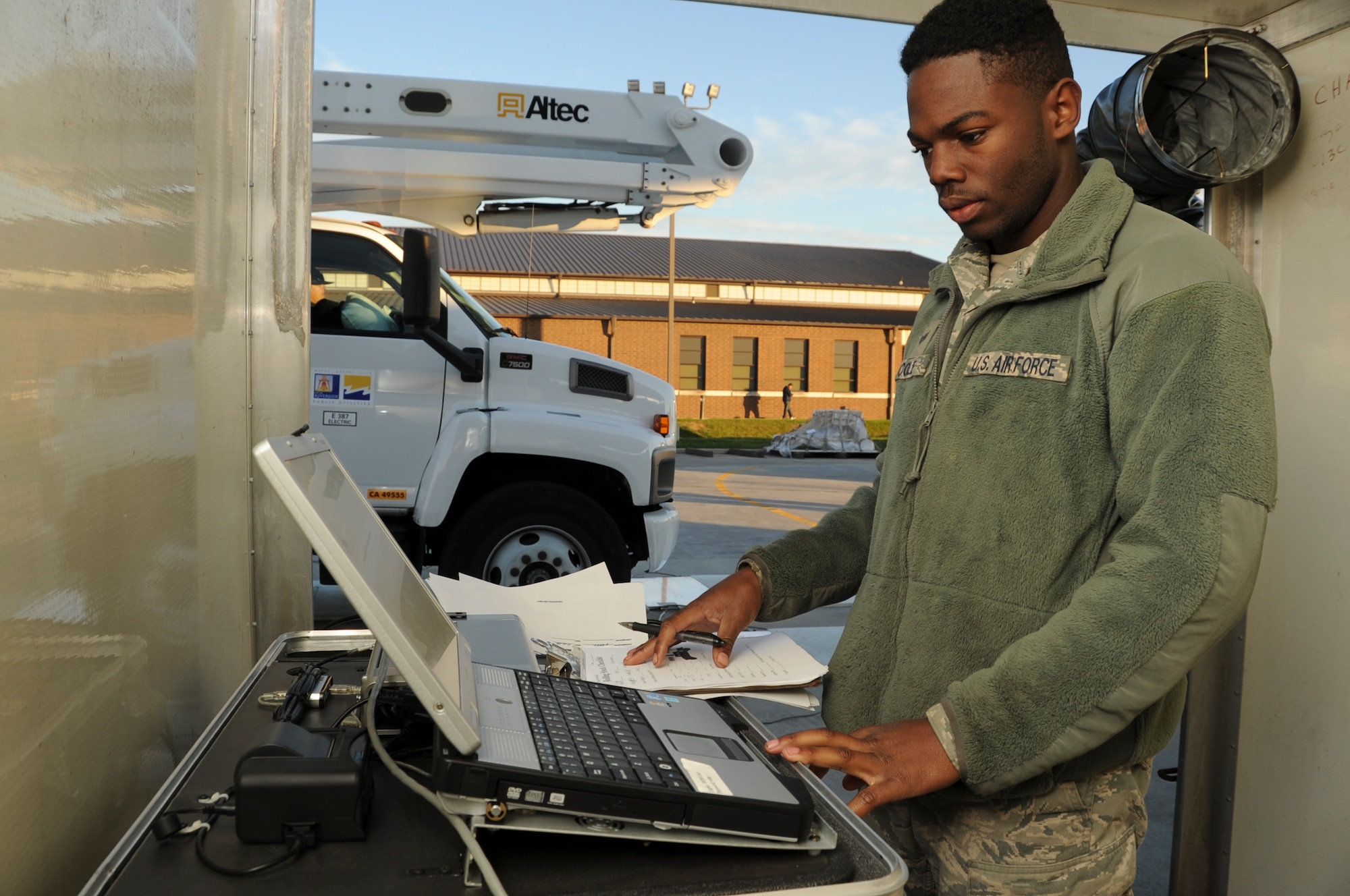Senior Airman Marquis Cole, 305th Aerial Port Squadron aerial transportation specialist, monitors a Deployable Automated Cargo Measurement System computer Nov. 16, 2012, as a utility and line truck passes through DACMS at Joint Base McGuire-Dix-Lakehurst, N.J., to determine if the truck’s approximate size and weight. Cole is an Independence, La., native. (U.S. Air Force photo by Staff Sgt. David Carbajal/Released)