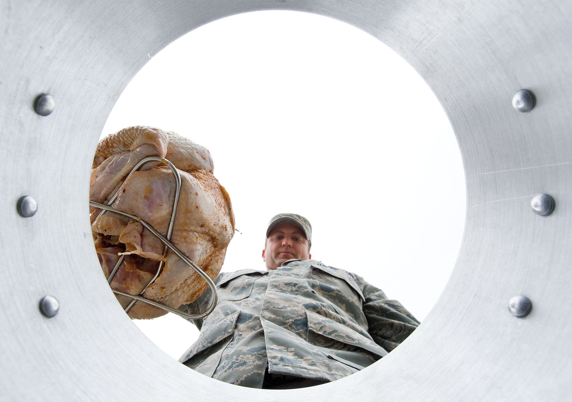 Master Sgt. John Willard lowers a turkey into a turkey fryer at Dover Air Force Base, Del., Nov. 16, 2012. Fires caused by improper usage of turkey fryers are one of the top causes for home fires during the holiday season. Willard is the NCO in charge of flight safety with the 436th Airlift Wing Safety Office. (U.S. Air Force photo/Roland Balik)