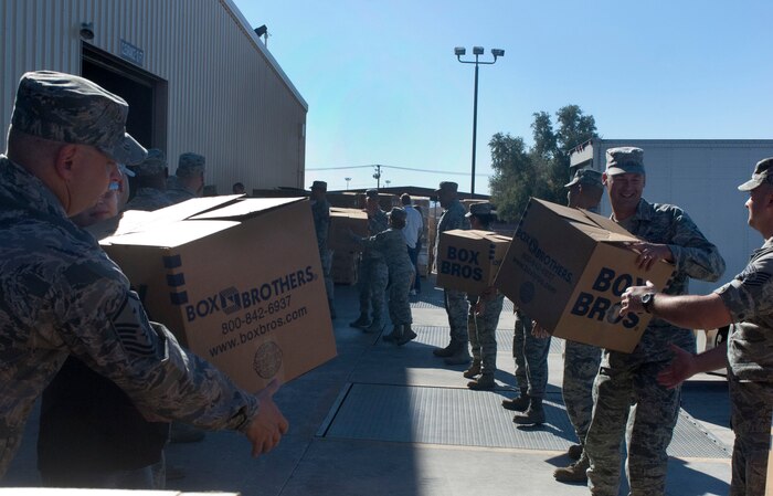NELLIS AIR FORCE BASE, Nev. – Volunteer Airmen move boxes filled with food donated by the Tug Boat association for Operation Warm Heart Nov. 13, 2012, at Nellis Air Force Base, Nev. Operation Warm Heart donates complete Thanksgiving dinners to Nellis and Creech AFB families. (U.S. Air Force photo by Senior Airman Jack Sanders)