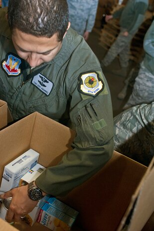 NELLIS AIR FORCE BASE, Nev. – Tech. Sgt. Eric Agundez, 26th Weapons Squadron instructor sensor operator, packs food items donated by the Tug Boat association into boxes for Operation Warm Heart Nov. 13, 2012, at Nellis Air Force Base, Nev. Airmen from all around Nellis, Creech and the Nevada Test and Training Range volunteered to aid in Operation Warm Heart, an operation that donates Thanksgiving meals to Nellis and Creech families by loading and moving boxes with food. (U.S. Air Force photo by Senior Airman Jack Sanders)