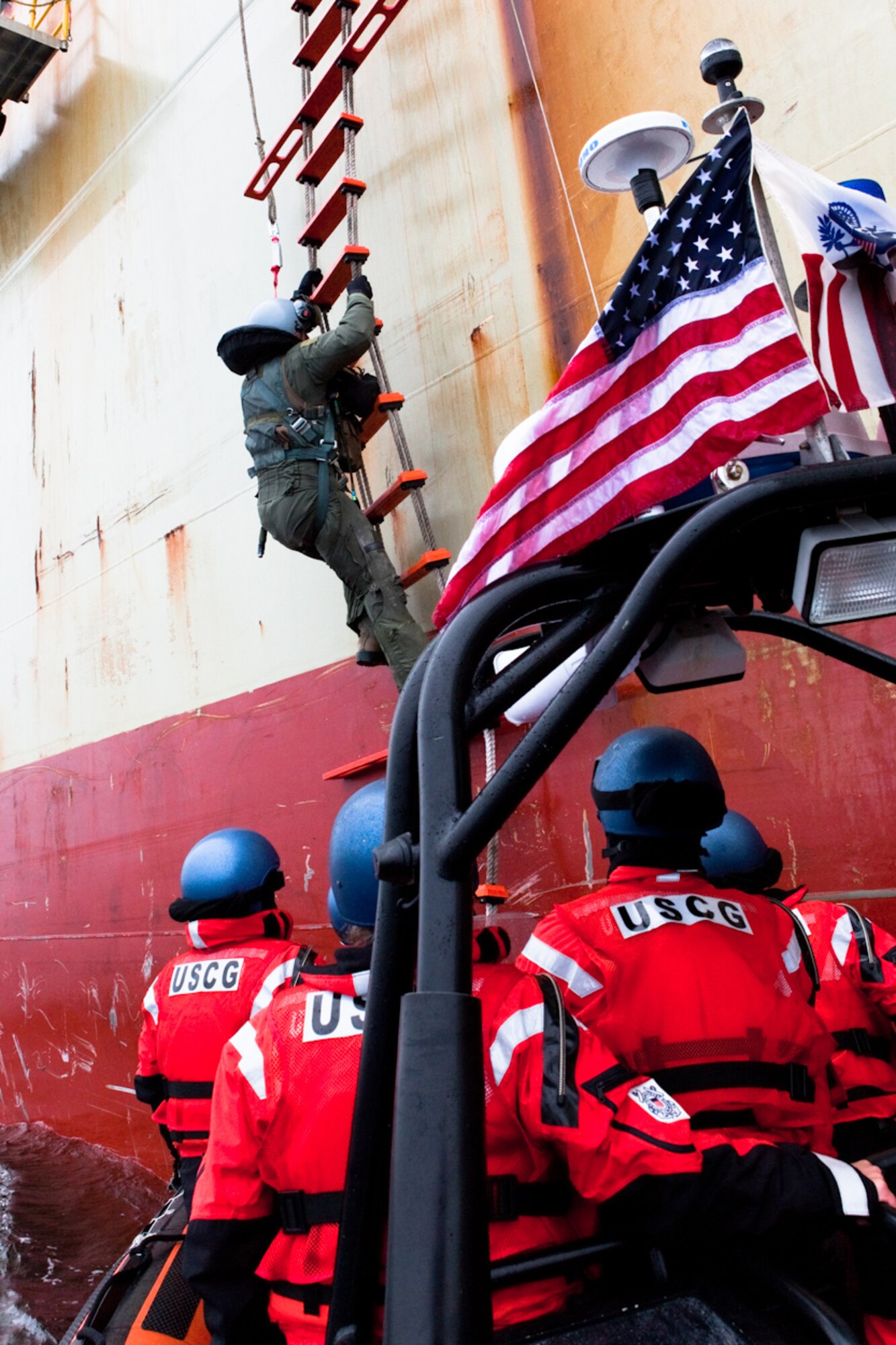 An Air Force pilot climbs down the Jacobs ladder of the cargo vessel Manukai to the Coast Guard Cutter Munro’s small boat crew on July 24. The pilot, who was forced to eject from his aircraft for unknown reasons, transited with the Munro to Dutch Harbor, Alaska, where he met an awaiting Air Force airplane for transit back to Japan. (U.S. Coast Guard courtesy photo)