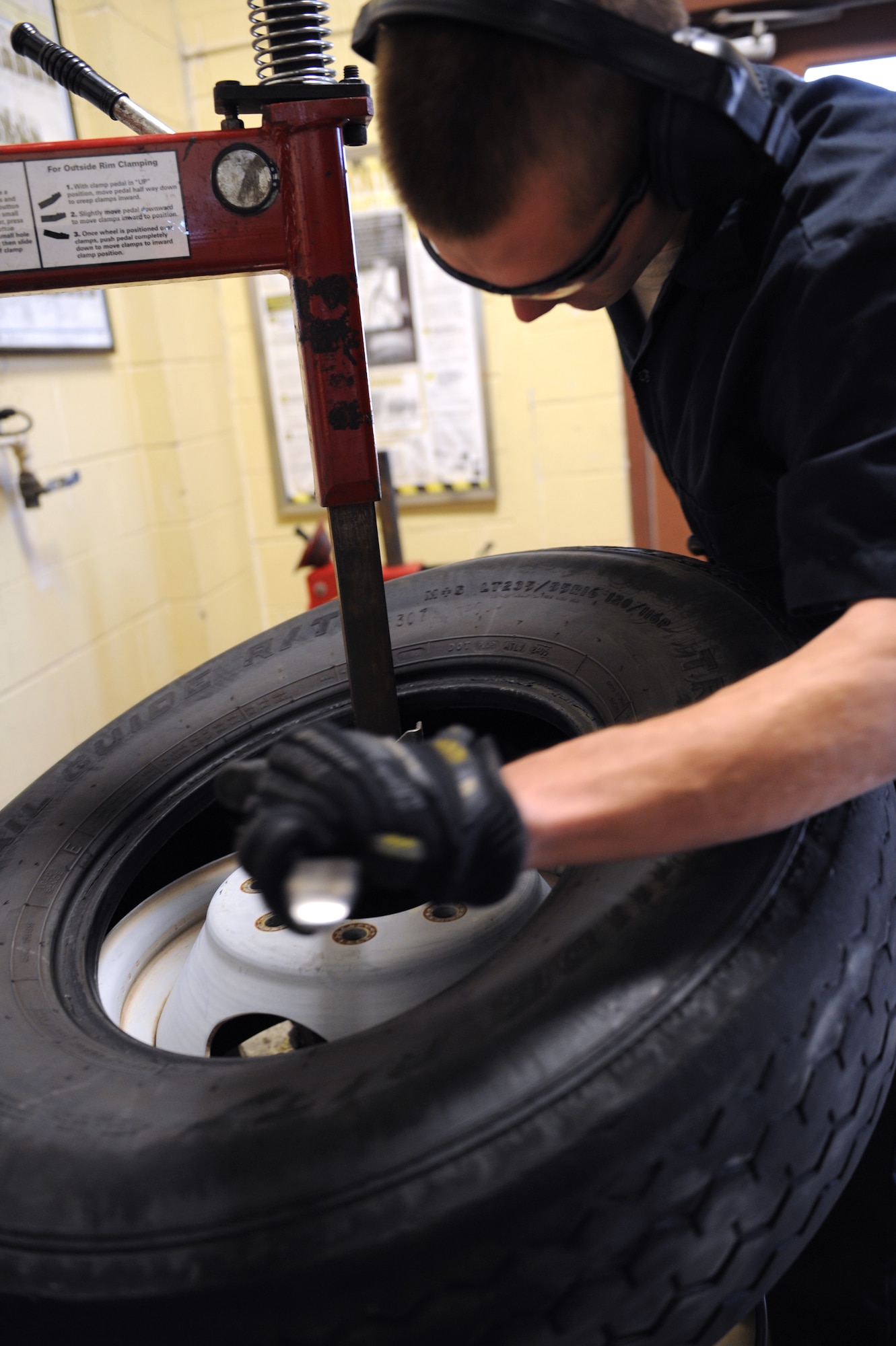 Airman 1st Class Kenneth Bates, 2nd Logistics Readiness Squadron Allied Trades section journeyman, removes a rim from a tire on Barksdale Air Force Base, La., Nov. 19. When a tire is worn out, it is demounted and replaced with a new one. The maintainers at the 2 LRS tire shop repair tires that contain nails, screws and bolts, broken valve stems, tires that have blown out from abnormal use, and wear and tear. They also perform more than 100 tire changes each month. (U.S. Air Force photo/Airman 1st Class Benjamin Gonsier)(RELEASED)
