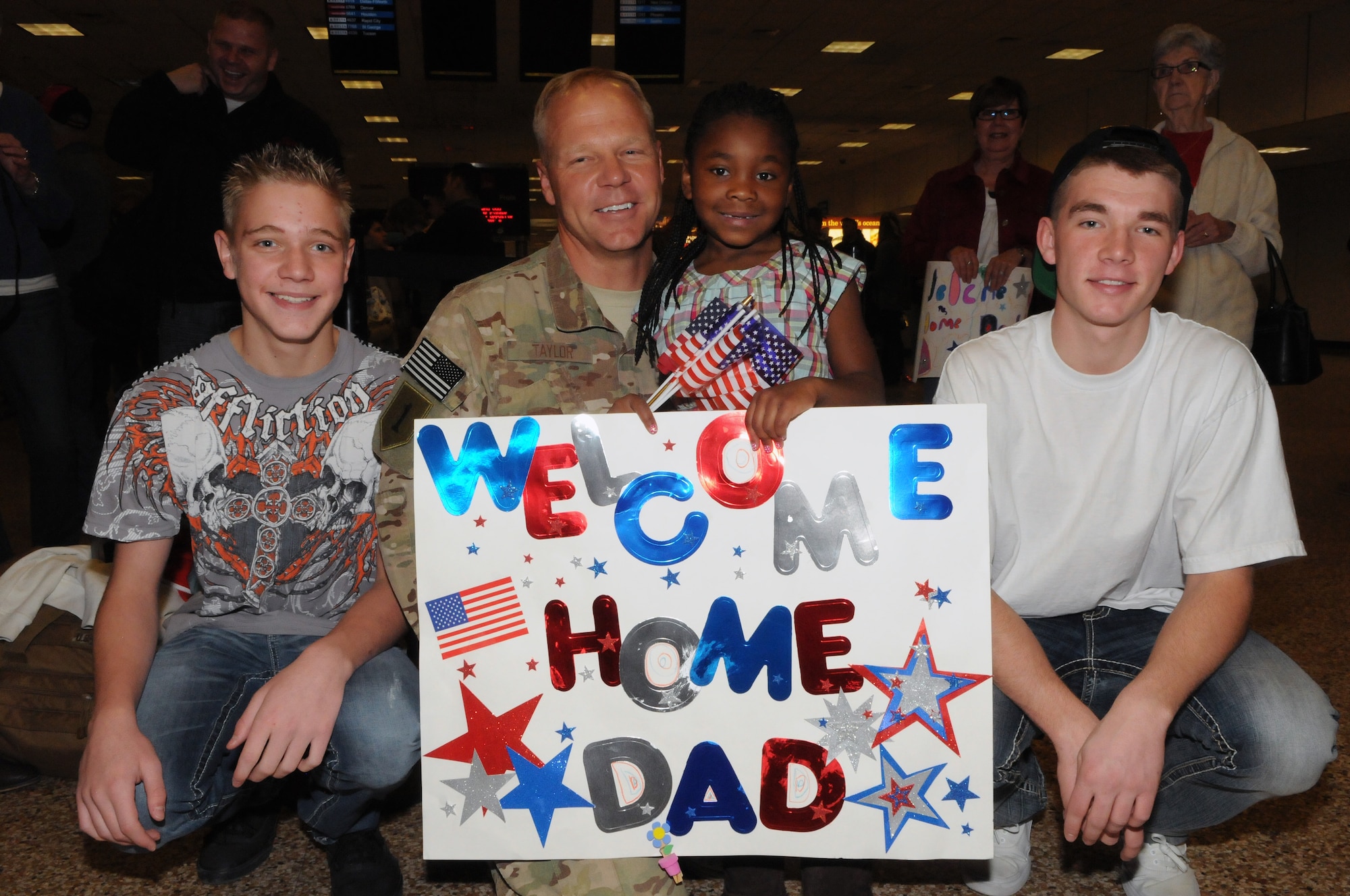 Master Sgt. Greg Taylor, posed with his family as he returned from deployment at the Salt Lake City International Airport, Nov. 16. Taylor and eleven other members of the 130th Engineering Installation Squadron served a six-month deployment in support of Operation Enduring Freedom throughout several forward operating bases in Afghanistan. (U.S. Air Force photo by Staff Sgt. Joe Davis)(RELEASED)