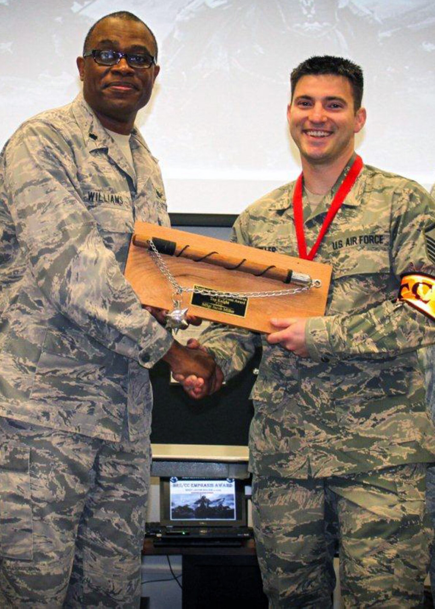 Lt. Col. Jerome Williams (left), Northern Recruiting Squadron commander, presents Master Sgt. Jacob Miller, 914th Airlift Wing line recruiter, with the Commander’s Emphasis Award for most accessions in the squadron for Fiscal Year 2012.  This award was presented at the Air Force Reserve Recruiting awards banquet October 25 in Savannah, Ga.  (Courtesy photo)