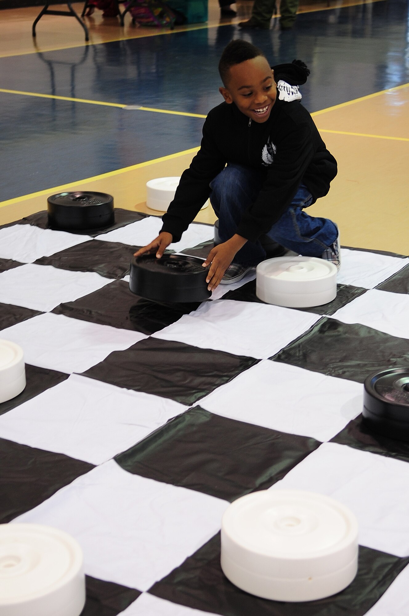 Cedric Newton, 8, plays checkers during the Month of the Military Family Block Party on Seymour Johnson Air Force Base, N.C., Nov. 17, 2012. Several games including checkers, Connect Four, and cornhole were available for families to play together. Cedric is the son of U.S. Air Force Staff Sgt. Niquita Newton, a 4th Equipment Maintenance Squadron armament systems technician. (U.S. Air Force photo/Airman 1st Class Aubrey White/Released)