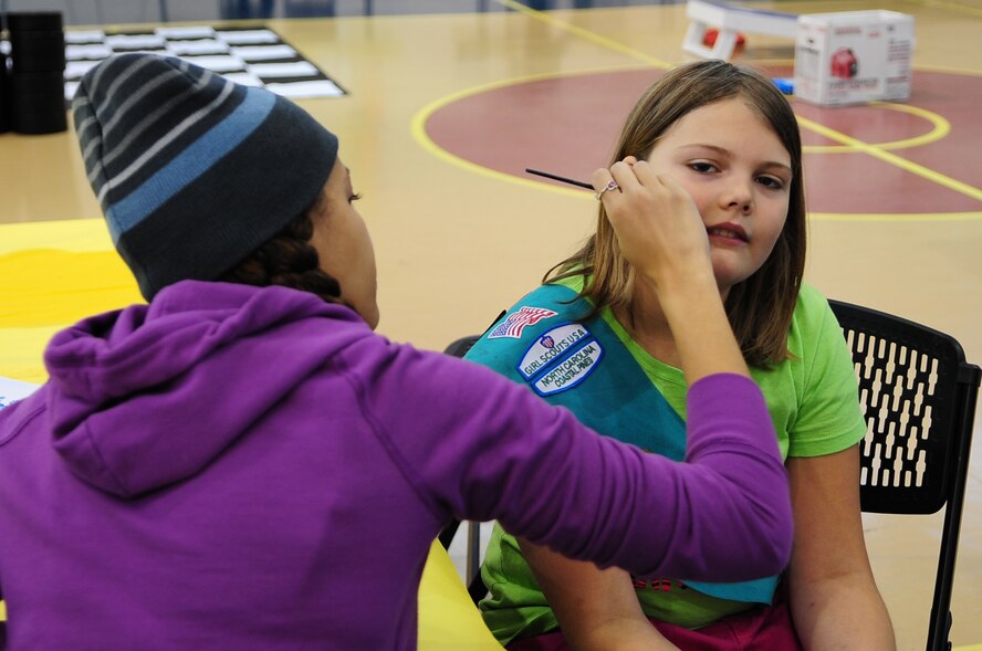 U.S. Air Force Airman 1st Class Bryanna Grant, 4th Operations Support Squadron intelligence analyst, paints Angel Hill’s face during the Month of the Military Family Block Party on Seymour Johnson Air Force Base, N.C., Nov. 17, 2012. Several Airmen volunteered to assist with games, horse rides and activities. Angel, 12, is a member of a local Girl Scout troop. (U.S. Air Force photo/Airman 1st Class Aubrey White/Released)