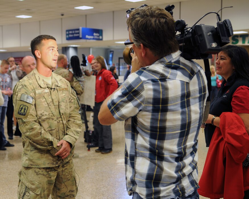 Senior Airman Cody Hard talked with a camera crew from a local news station after he returned from deployment at the Salt Lake City International Airport, Nov. 16. Hard and eleven other members of the 130th Engineering Installation Squadron served a six-month deployment in support of Operation Enduring Freedom throughout several forward operating bases in Afghanistan. (U.S. Air Force photo by Staff Sgt. Joe Davis)(RELEASED)