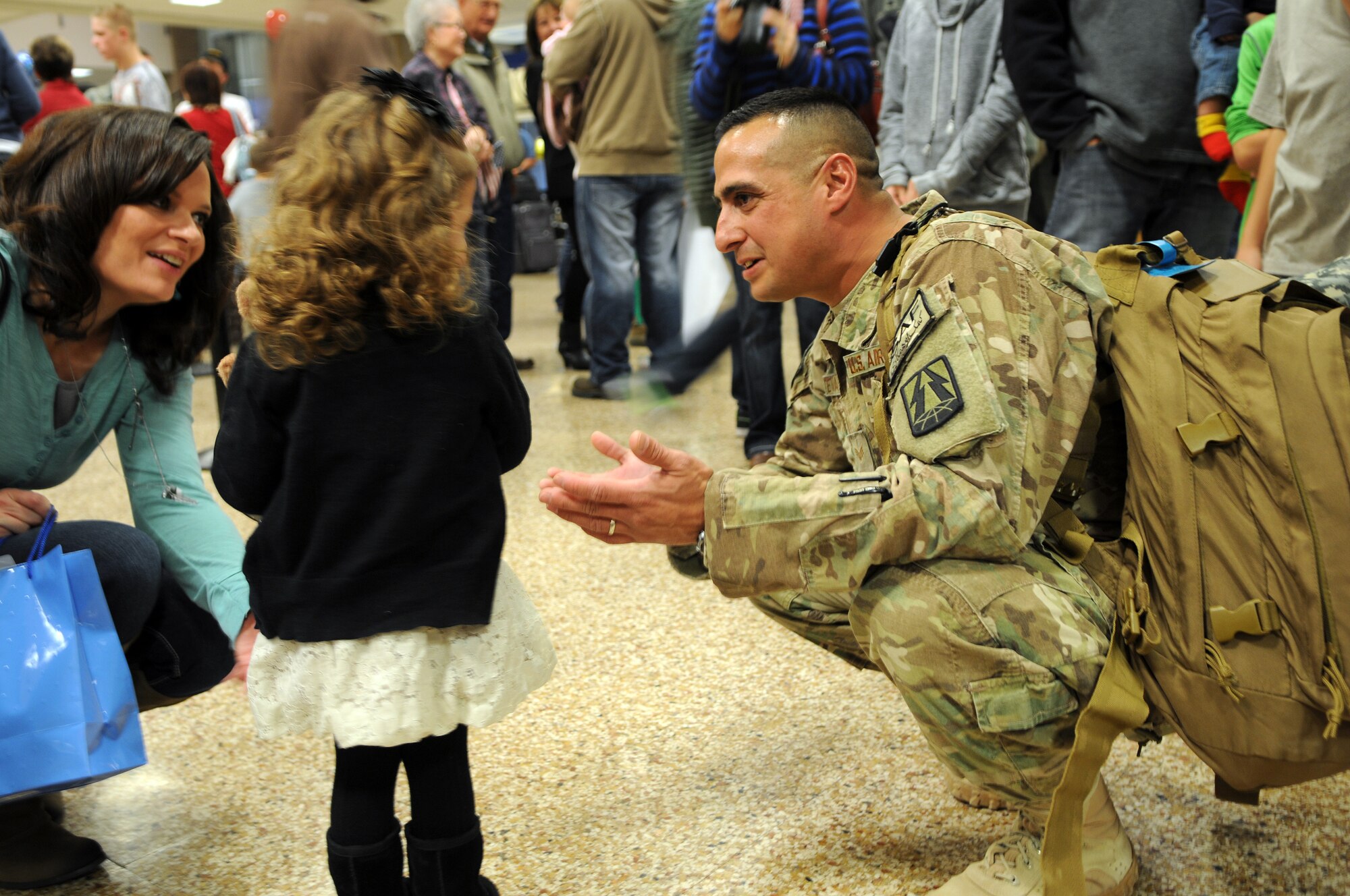 Senior Airman Dave Santistevan greeted his wife, Tiffany, and asked his young daughter for a hug after he returned from deployment at the Salt Lake City International Airport, Nov. 16. Santistevan and eleven other members of the 130th Engineering Installation Squadron served a six-month deployment in support of Operation Enduring Freedom throughout several forward operating bases in Afghanistan. (U.S. Air Force photo by Staff Sgt. Joe Davis)(RELEASED)