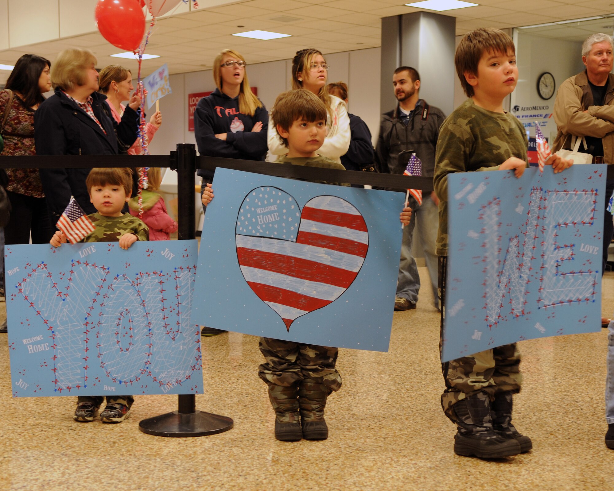 The three sons of Staff Sgt. Christian Ward waited to welcome home their dad as he returned from deployment at the Salt Lake City International Airport, Nov. 16. Ward and eleven other members of the 130th Engineering Installation Squadron served a six-month deployment in support of Operation Enduring Freedom throughout several forward operating bases in Afghanistan. (U.S. Air Force photo by Senior Airman Lillian Harnden)(RELEASED)