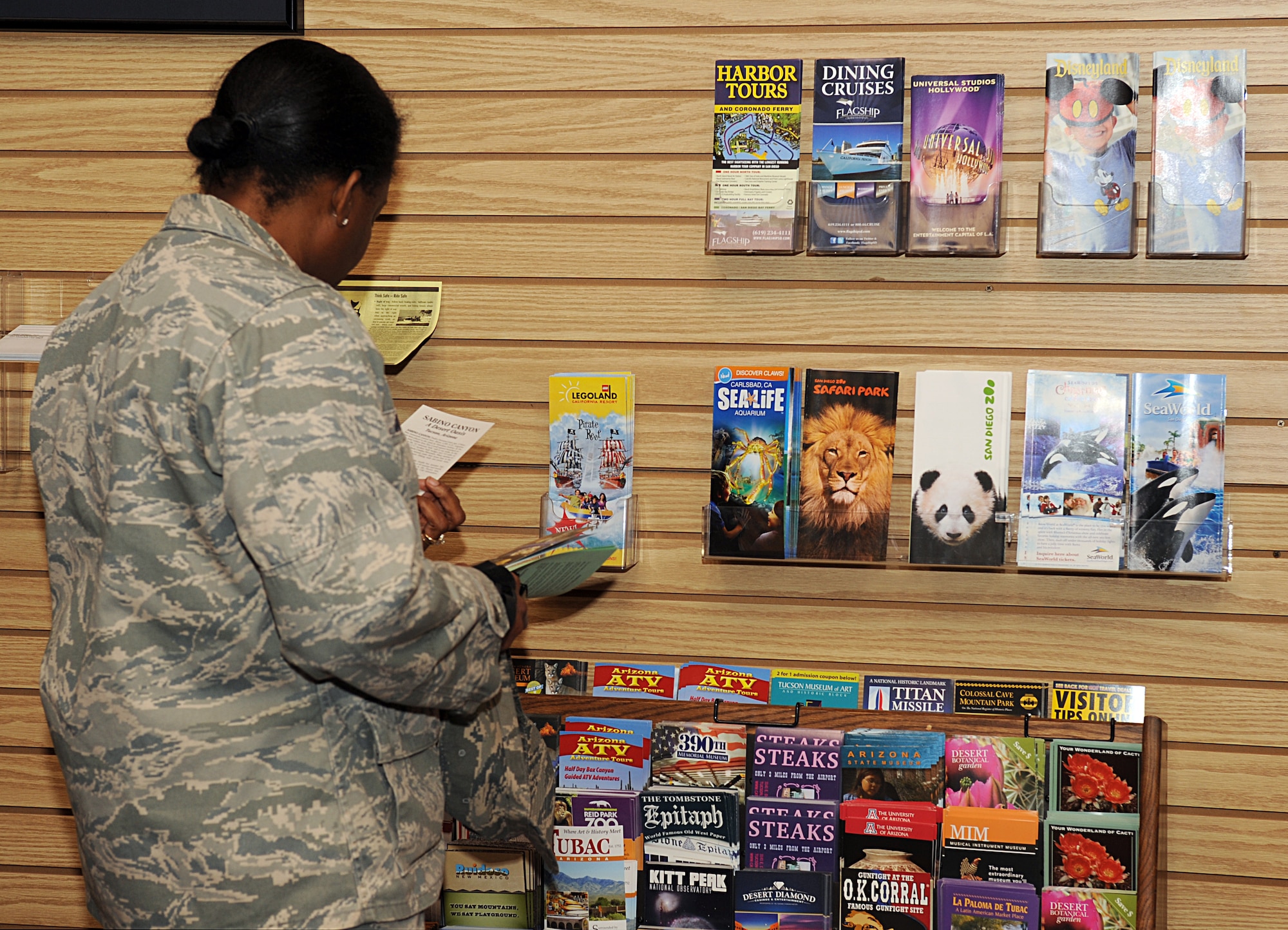 U.S. Air Force Maj. Jennifer Johnson looks at brochures for some of the attractions offered by Information, Tickets, and Tours on Davis-Monthan Air Force Base, Ariz., Nov. 14, 2012. Information, Tickets, and Tours offers discount tickets to all  U.S. Armed Forces members, retirees, and civilian Department of Defense employees. (U.S. Air Force photo by Senior Airman Timothy Moore/Released)