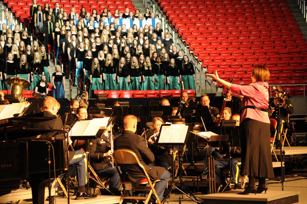 Leah Tarrant conducts "America, the Dream Goes On" with the 23rd Army Band and a 600-voice combined choir from Granite School District high schools. The production was part of the Utah National Guard's 57th annual Veterans Day concert at the University of Utah's Jon M. Huntsman Center, Nov. 10. (U.S. Air Force photo by Senior Airman Lillian Harnden)(RELEASED)