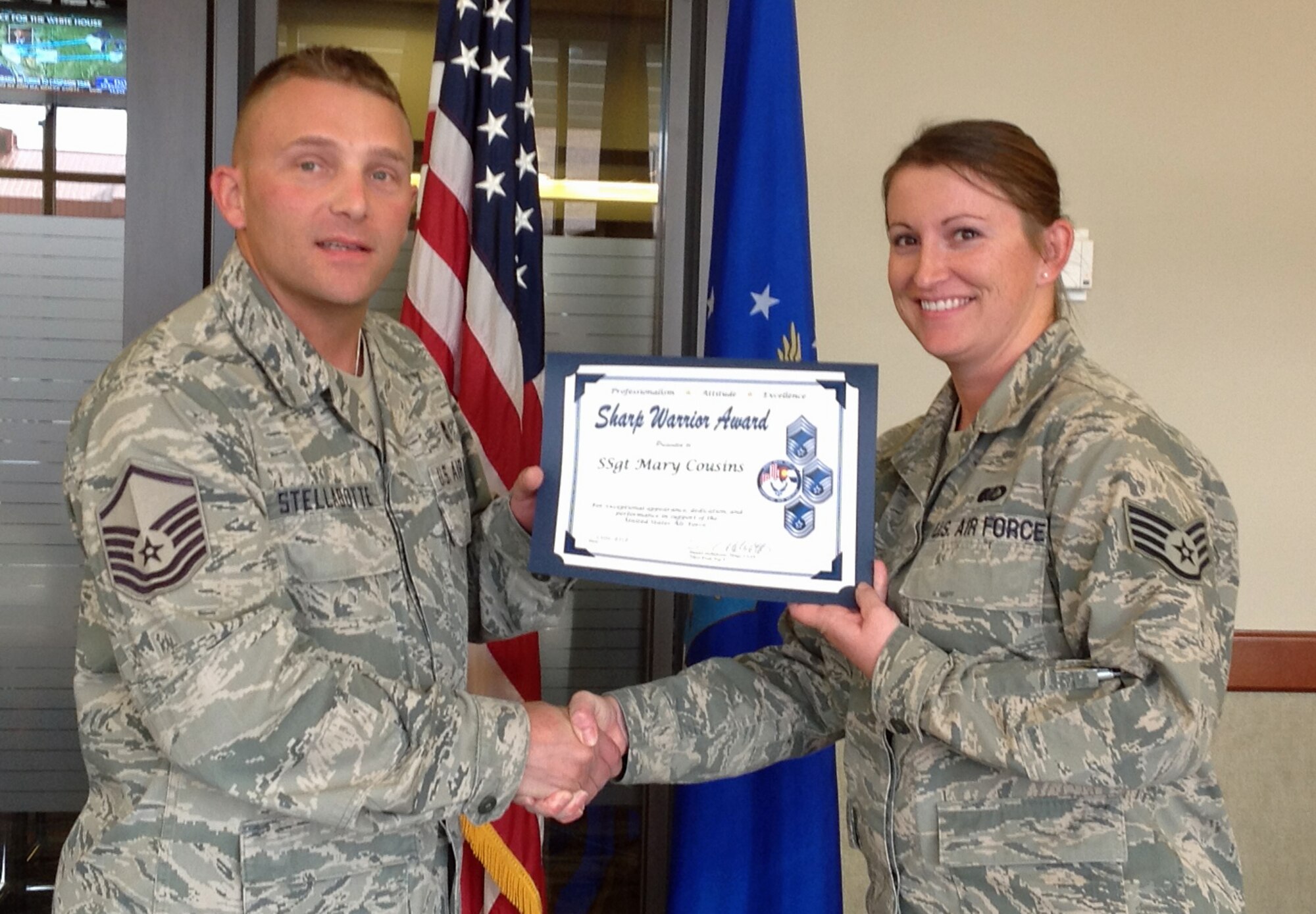 PETERSON AIR FORCE BASE, Colo. -- Master Sgt. Dan Stellabotte, Team Pete career assistance advisor, presents the October 2012 Sharp Warrior Award to Staff Sgt. Mary Cousins, 21st Force Support Squadron, on behalf of the Pikes Peak Top 3. Cousins, who works in the Aragon Dining Facility, was recognized for her outstanding customer service and dedication, providing meal support for two Reserve units consisting of more than 500 personnel. The Sharp Warrior Award recognizes Team Pete Airmen who portray the whole person concept, and go above and beyond their normal day-to-day operations. (U.S. Air Force photo)