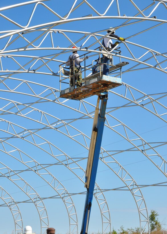 Contractors install aluminum framework tubing during construction of a new storage unit for the 919th Logistics Readiness Squadron at Duke Field, Fla. Covered in a thick canvas material, the portable, Quonset hut-shaped structure provides the squadron with a low-cost, highly weather-protective shelter for deploying forces and their equipment. (U.S. Air Force photo/Dan Neely)