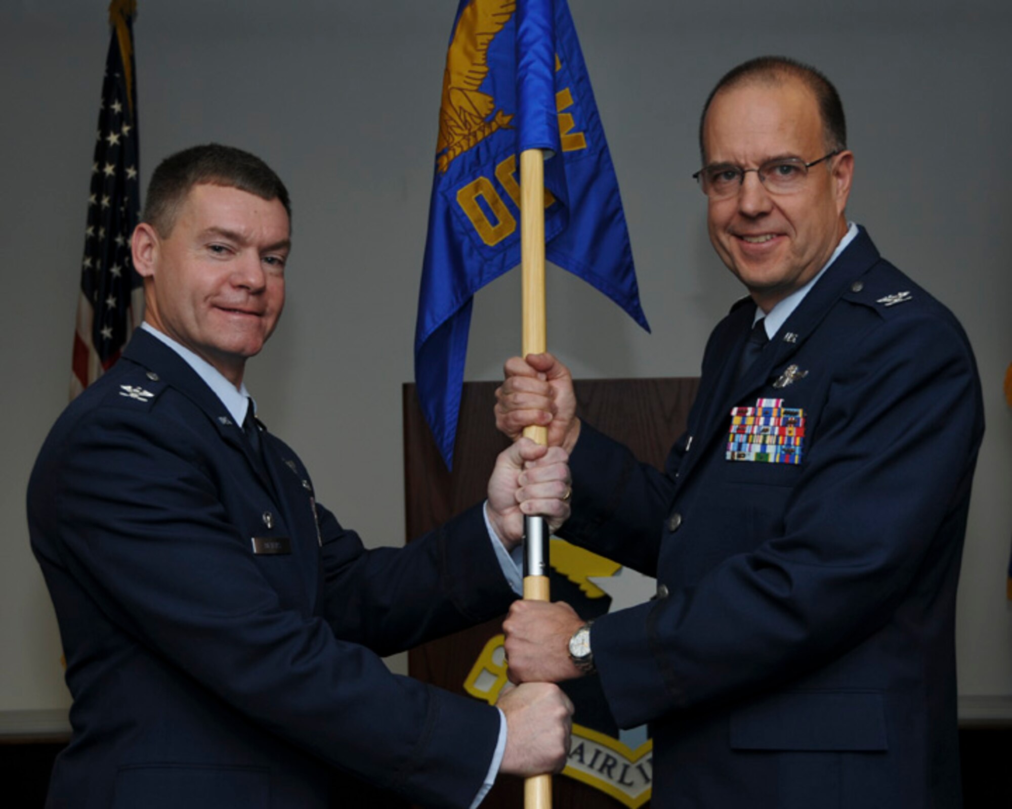 : Col. Craig C. Peters, 911th Airlift Wing commander passes the 911th Operations Group guidon to Col. Joseph M. Potts, 911th Operations Group commander, during an assumption of command ceremony held here, Nov. 4, 2012.  Upon assuming command, Potts spoke briefly to Airmen about staying focused on the mission as well as sustaining the U.S. Air Force core values:” Integrity first, Service before self and Excellence in all we do.” Potts a Johnstown, Pa. native comes to the 911th after serving four years as the 328th Airlift Squadron operations officer and interm commander. (U.S. Air Force photo by Senior Airman Joshua J. Seybert/Released)
