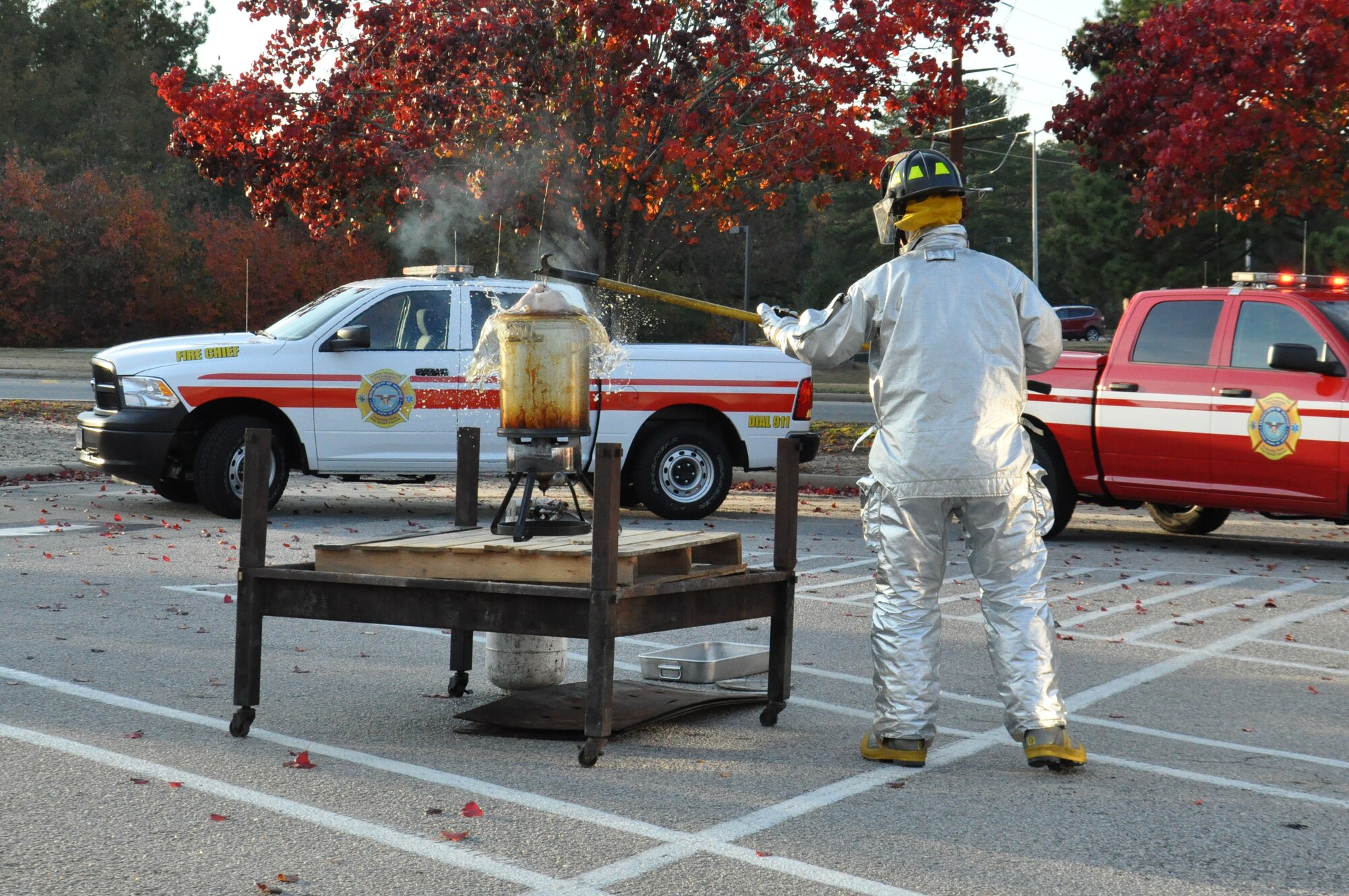 U.S. Air Force Senior Airman Daniel Gough, 4th Civil Engineer Squadron fire fighter, drops a frozen turkey into a deep fryer during a Turkey Fryer Fire demonstration on Seymour Johnson Air Force Base, N.C., Nov. 16, 2012. The demonstration is held during the holiday season to show members of Team Seymour the dangers associated with frying a turkey without taking necessary safety precautions. (U.S. Air Force photo/Airman 1st Class Mariah Tolbert/Released)