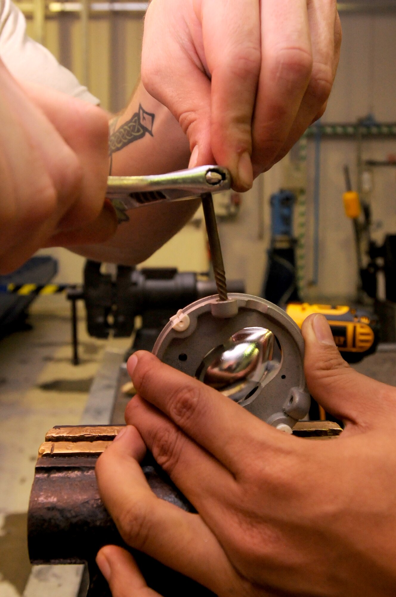 SOUTHWEST ASIA -- U.S. Air Force Staff Sgt. Ryan McCune and Senior Airman Mark Calderon, 380th Expeditionary Maintenance Squadron fabrication flight metals technologists, work to remove broken hardware from an aircraft light fixture Nov. 19, 2012. The 380th EMXS fabrication flight metals technology section, also called the machine shop, is responsible for the flight's machine and welding jobs. (U.S. Air Force photo/Tech. Sgt. Amanda Savannah)