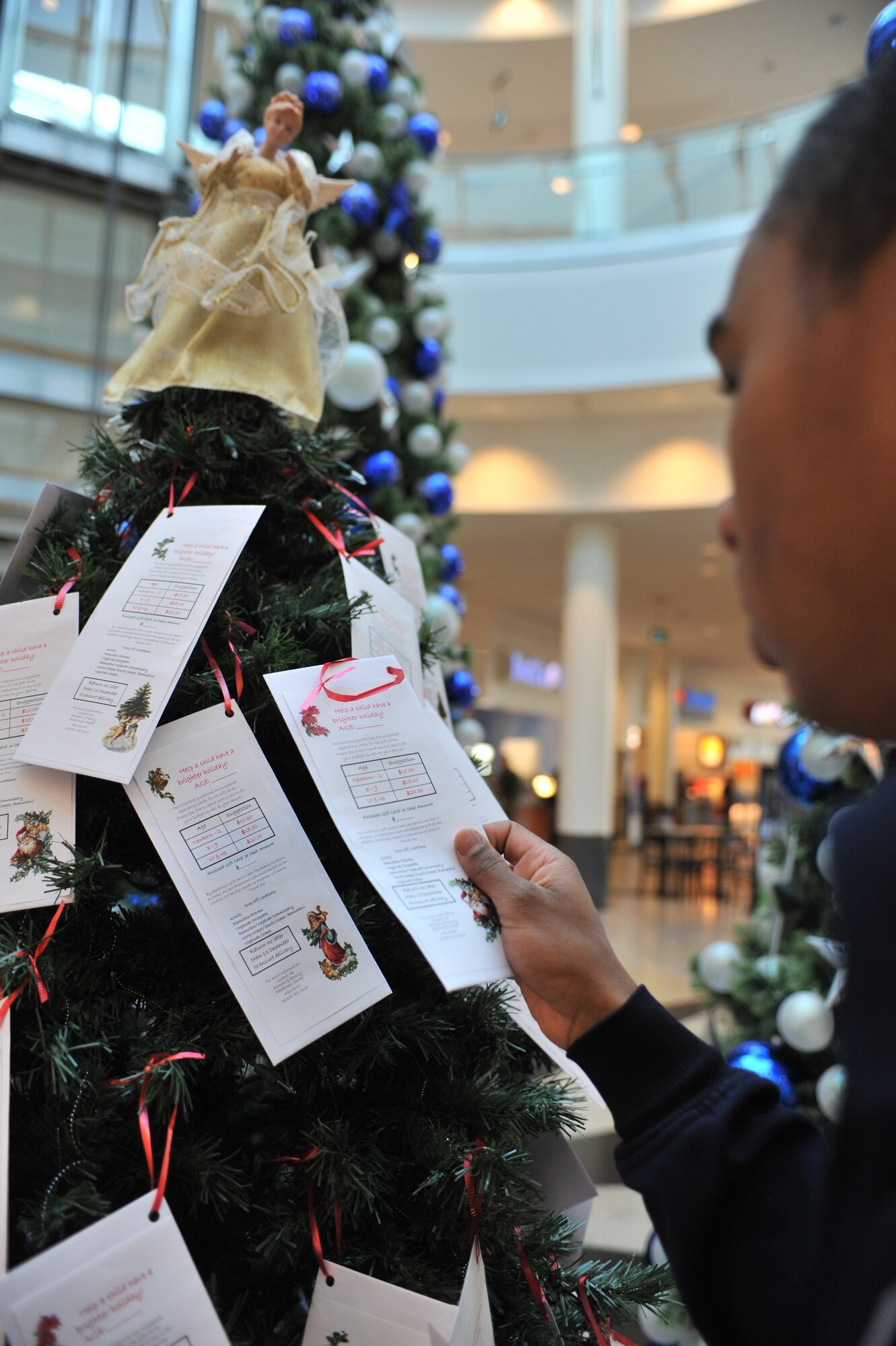 Senior Airman Aaron-Forest Wainwright takes an envelope from the Angel Tree in the Kaiserslautern Military Community Center on Ramstein Air Base, Germany, Nov. 19, 2012. The Angel Tree program provides financial relief which helps in the purchase of gifts for children during the holiday season. (U.S. Air Force photo/Senior Airman Caitlin O’Neil-McKeown)

