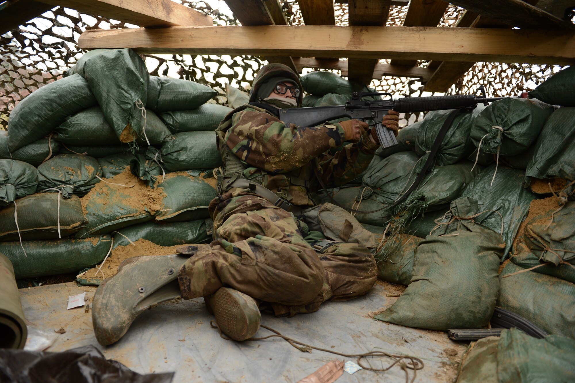 SPANGDAHLEM AIR BASE, Germany – U.S. Air Force Airman 1st Class Robert Brown, 606th Air Control Squadron radio frequency transmissions operator from Rochester, Ind., guards the base inside a makeshift defensive fighting position during combat readiness training Nov. 15, 2012. The 606th has many support Air Force specialty codes, which means many of its Airmen have never gone through any sort of combat training. This training gives 606th Airmen an opportunity to experience their new combat roles and prepares them for deployments. (U.S. Air Force photo by Staff Sgt. Nathanael Callon/Released)