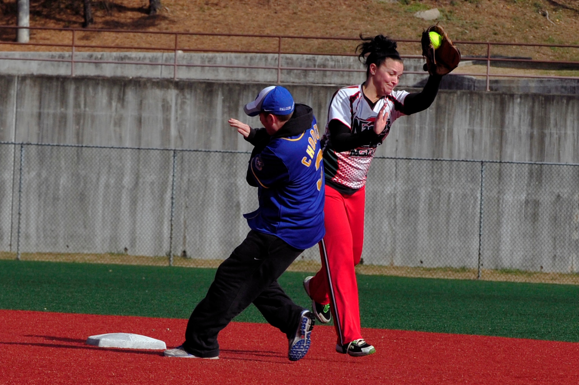 Staff Sgt. Lynsey Bruzzi, 51st Security Forces Squadron member, tags out 2nd Lt. Matthew DeMars, 7th Air Force deputy chief of intelligence, surveillance and reconnaissance operations, in the 15th Annual Toys for Tots Softball Tournament at Osan Air Base, Republic of Korea, Nov. 17, 2012. Four teams of 12 players competed in the day-long completion in the cold weather to contribute to Toys for Tots. (U.S. Air Force photo/Airman 1st Class Alexis Siekert)