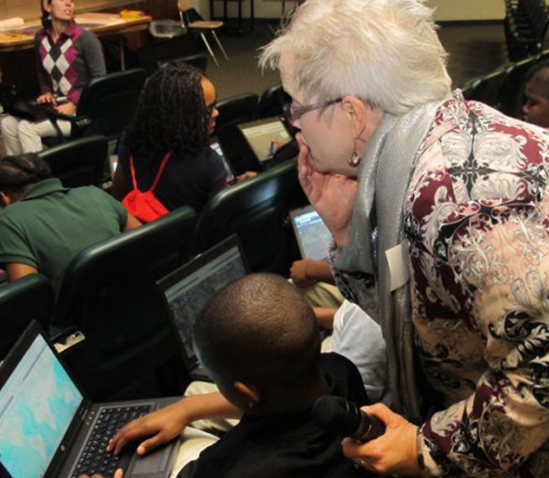 Beverly Richey, geographer and GIS specialist at Huntsville Center, helps a sixth-grader at Ed White Middle School use an online map Nov. 14 during a Geographic Information System activity at the school. More than 150 sixth-graders participated in the GIS Day workshop led by the Corps of Engineers Huntsville Center employees. The school was among six schools in Alabama that observed GIS Day.