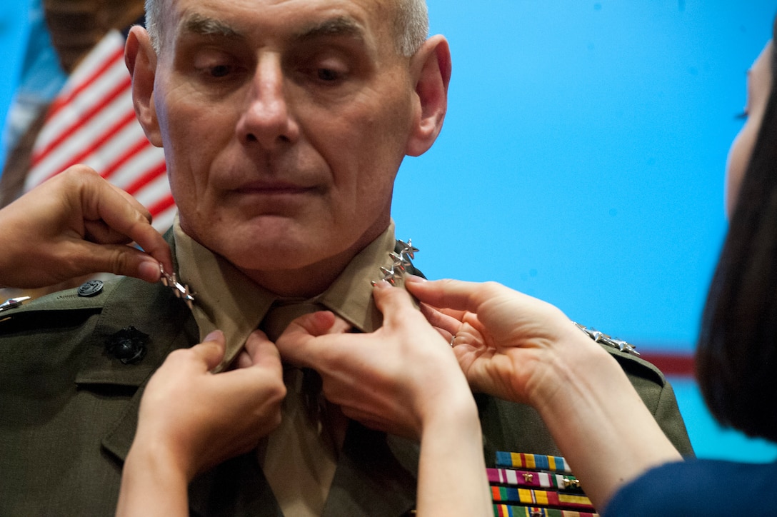 Marine Corps Gen. John F. Kelly stands as his daughter, Kate, and daughter-in-law, Heather, pin his fourth star to his collar before the U.S. Southern Command's change-of-command ceremony in Miami, Nov. 19, 2012.