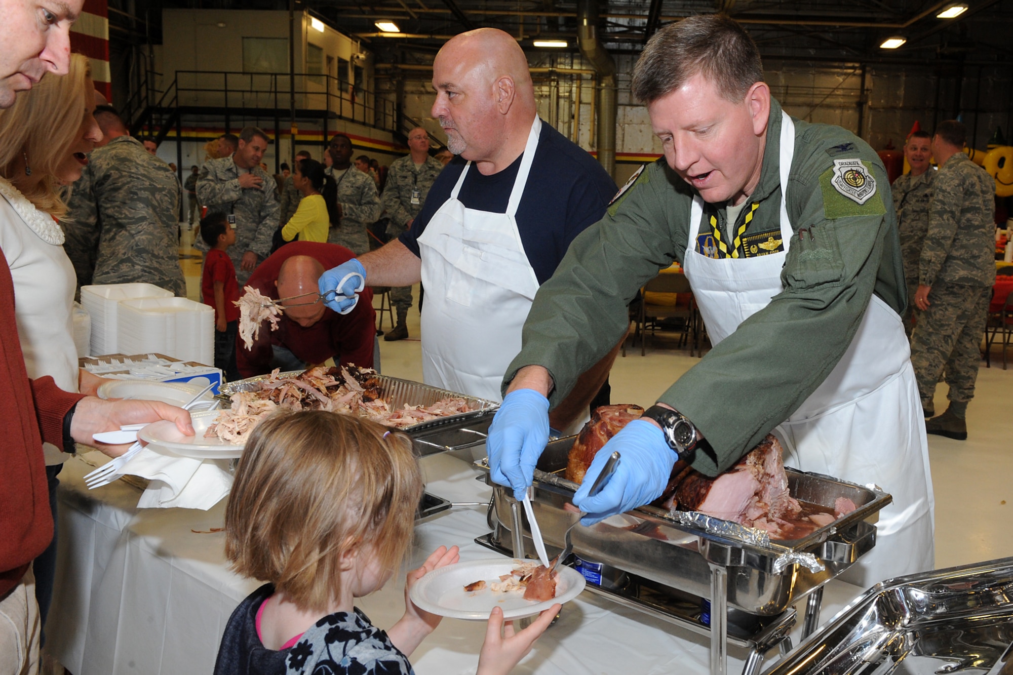 Col. Bryan Cook (right), 419th Operations Group commander, and Steve Curtis (center), Layton City mayor, serve food to Airmen and their families during a Thanksgiving feast here today. (U.S. Air Force photo/Alex Lloyd)