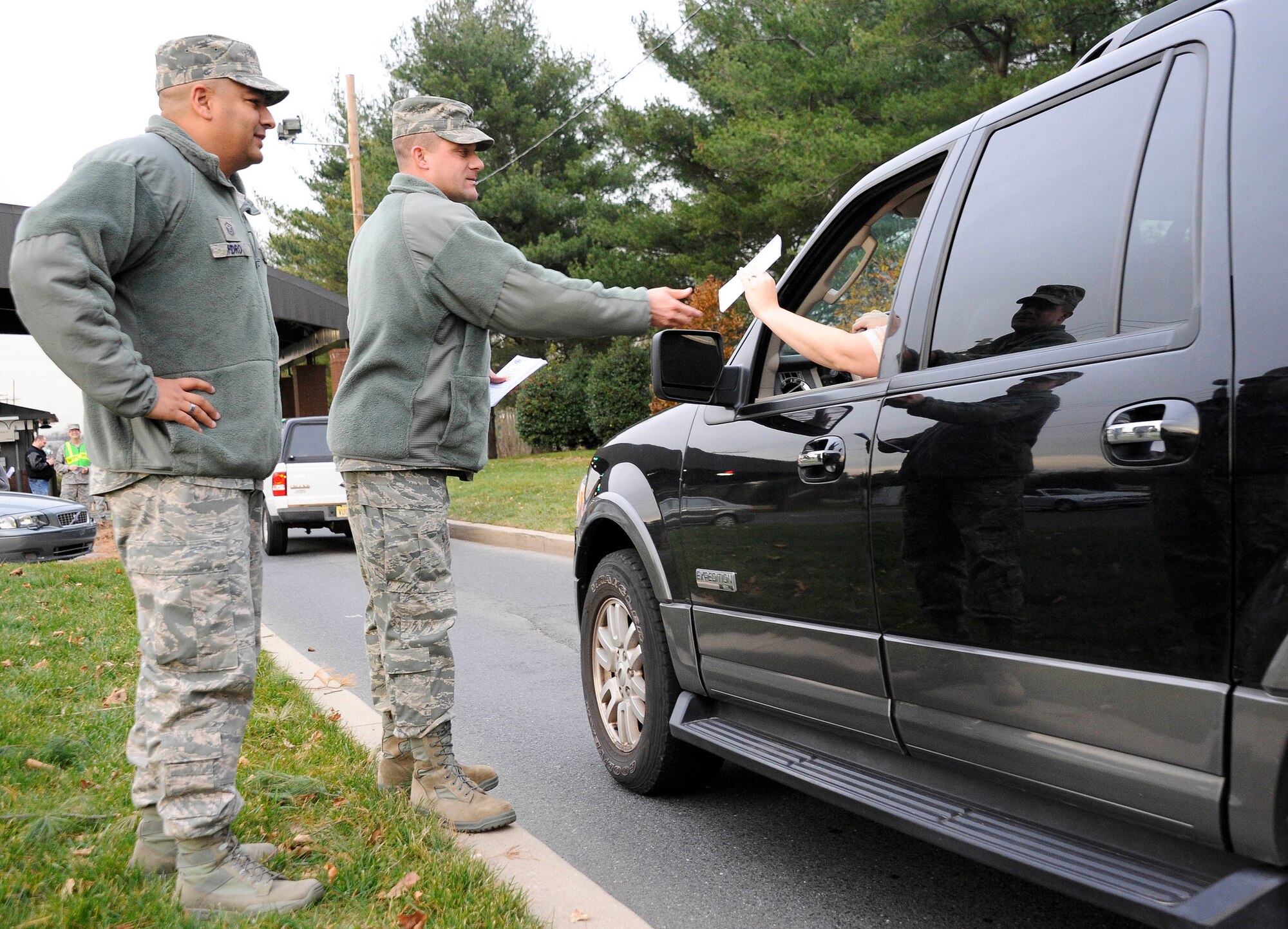 (Left) Master Sgt. Don Pedro, 305th Maintenance Squadron first sergeant, and Maj. Mark Szatkowski, 305th MXS commander, greets Joint Base McGuire-Dix-Lakehurst community members Nov. 20, 2012, as they exit the Wrightstown Gate. The base’s senior leaders, along with base safety personnel, wished all members a safe and happy holiday. (U.S Air Force photo by Airman 1st Class Ryan Throneberry/Released)