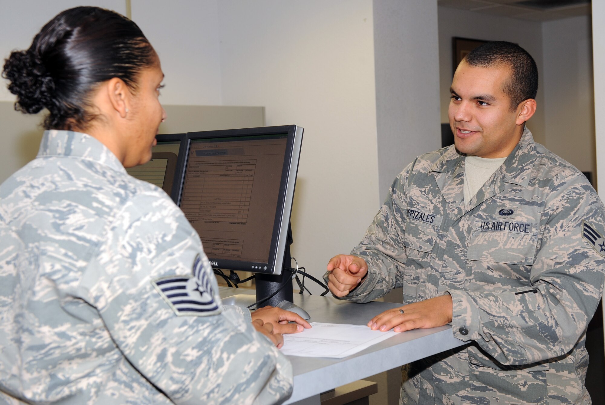 U.S. Air Force Senior Airman Robert Carrizales, 355th Communication Squadron client systems technician, helps a customer complete an AF form 2875, systems authorization access request, on Davis-Monthan Air Force Base, Ariz., Nov. 20. (U.S. Air Force photo by Senior Airman Brittany Dowdle)