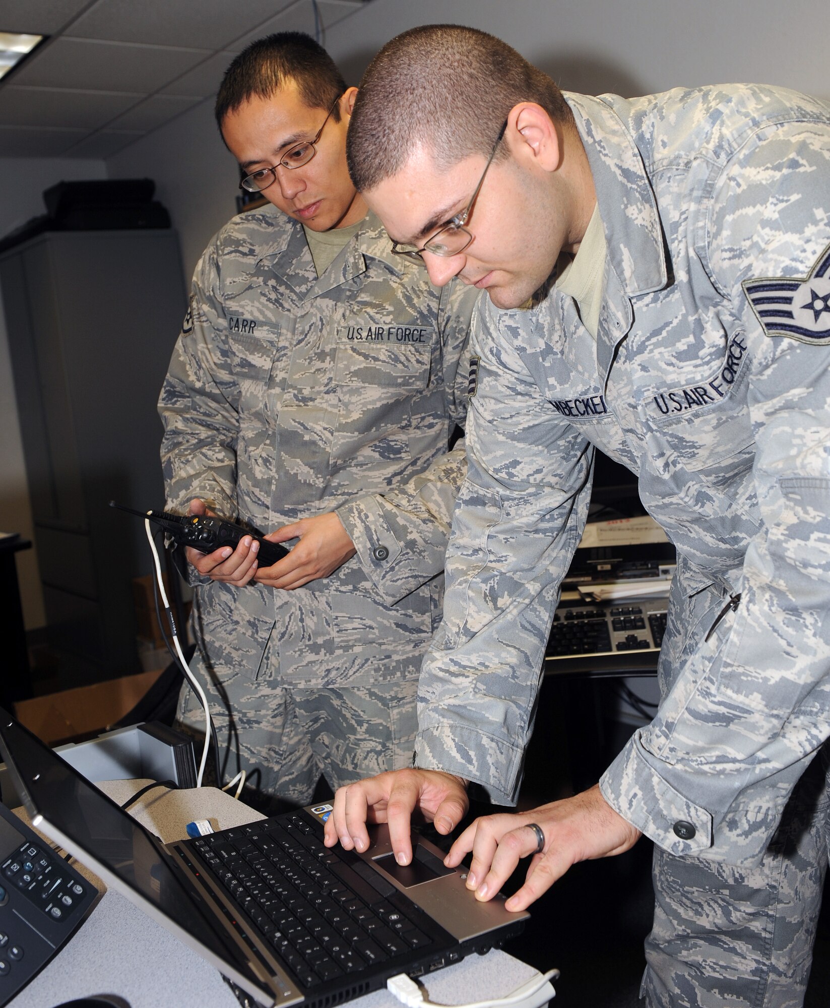 U.S. Air Force Staff Sgts. Adam Heimbecker and Joseph Car, 355th Communication Squadron client service technicians, program a radio for a use on Davis-Monthan air Force Base, Ariz., Nov. 20. (U.S. Air Force photo by Senior Airman Brittany Dowdle)