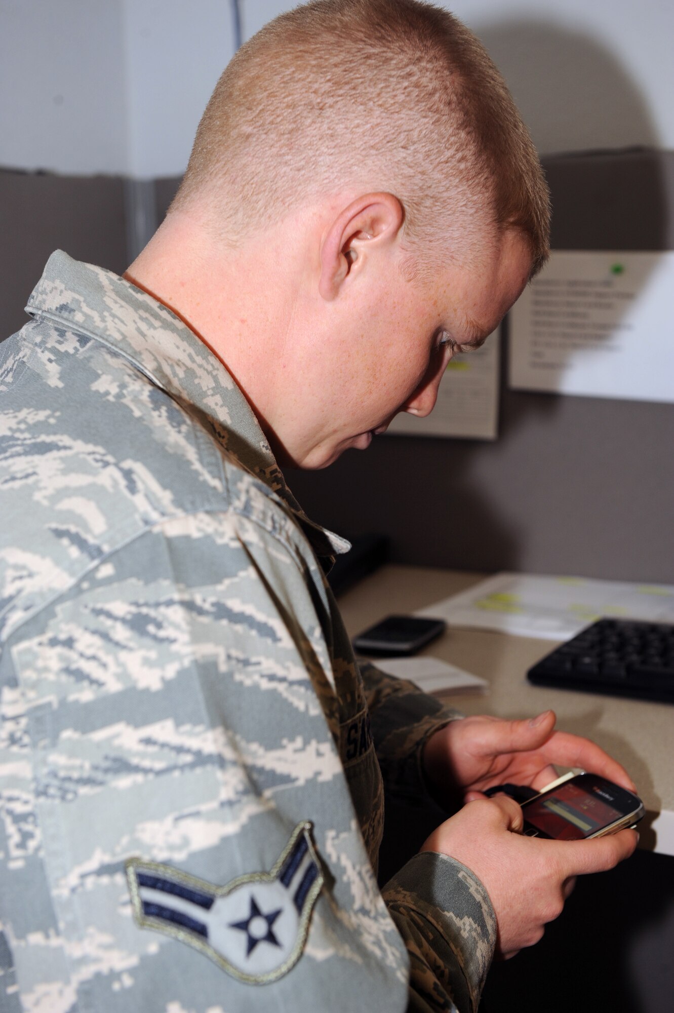 U.S. Air Force Airman 1st Class Jesse Sargent, 355th Communication Squadron client systems apprentice, works to configure a Blackberry for a customer on Davis-Monthan Air Force Base, Ariz., Nov. 20. (U.S. Air Force photo by Senior Airman Brittany Dowdle)
