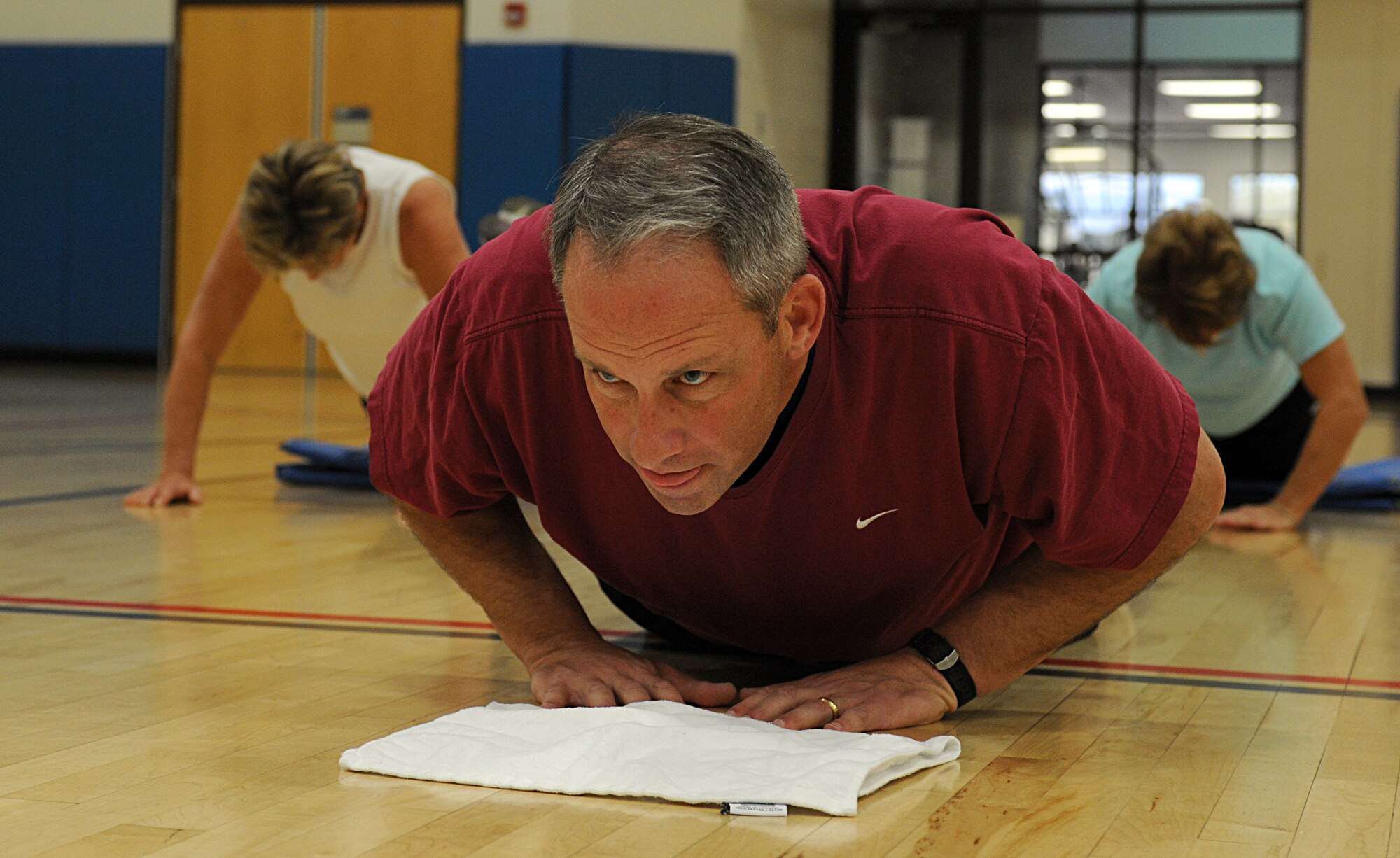 U.S. Air Force Col. Greg Williams, 355th Mission Support Group commander, performs a diamond pushup during the physical training portion of the Commander's 101/Surviving the Holidays course hosted by the Health and Wellness Center on Davis-Monthan Air Force Base, Ariz., Nov. 14, 2012. The course involved a PT class and a cooking demonstration led by members of the HAWC's staff. (U.S. Air Force photo by Senior Airman Timothy Moore/Released)