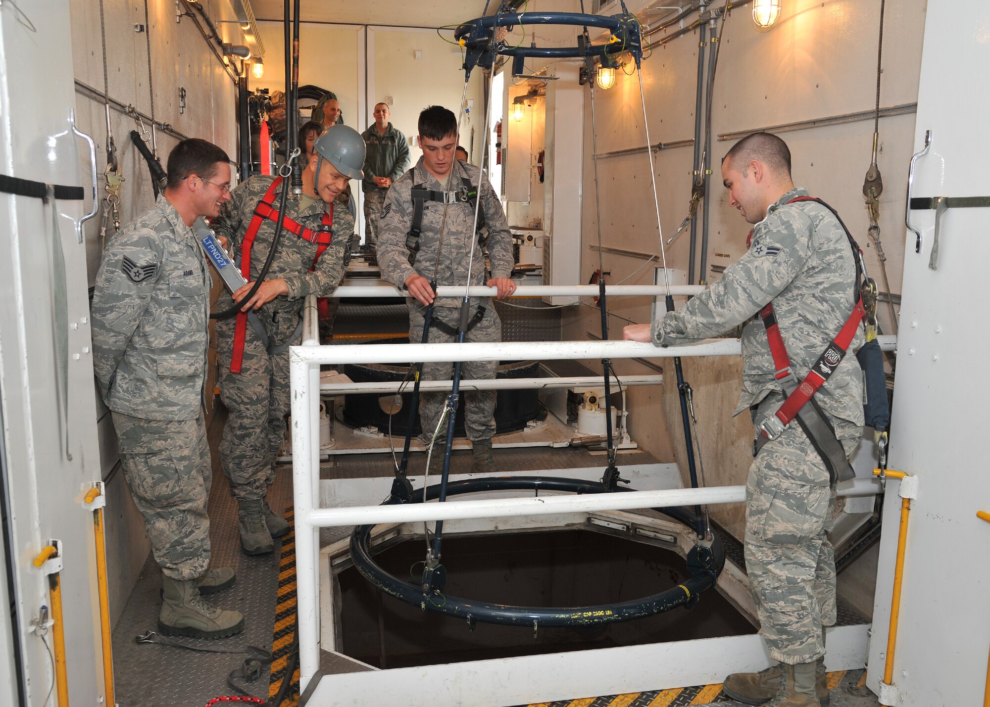 Chief Master Sergeant of the Air Force James Roy operates the hoist inside a Minuteman Payload Transporter III van, Nov. 20 at the T-9 maintenance trainer. Staff Sgts. Michael Adams and Michael Johnson, 341st Maintenance Operations Squadron team trainers, and Airman 1st Class Thomas Dekowski, a 341st Missile Maintenance Squadron tool room technician, observe and prepare to stow reentry system handling gear for transport. (U.S. Air Force photo/John Turner)