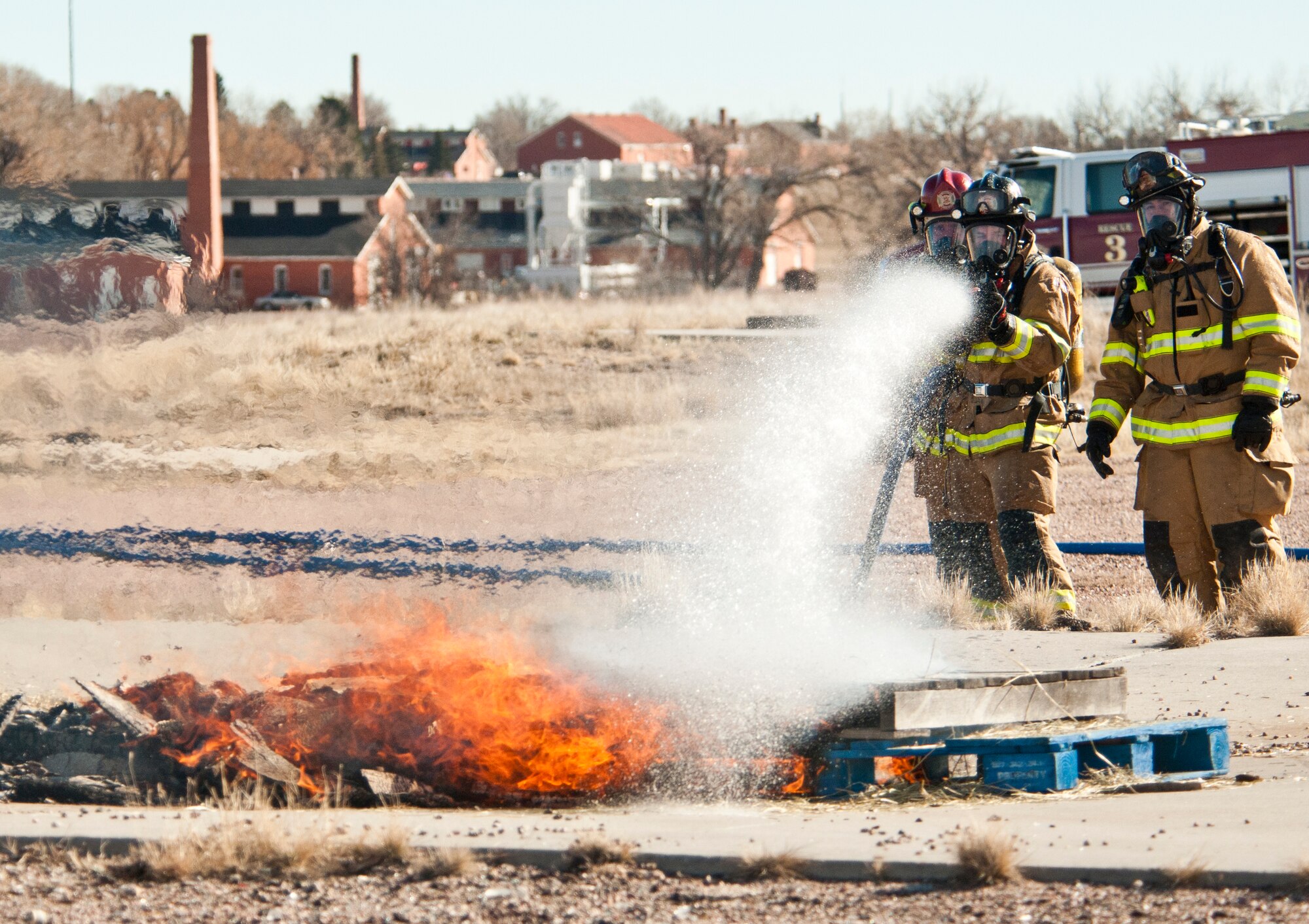 Firefighters with the 90th Civil Engineer Squadron extinguish pallets engulfed in flames during a live-fire training exercise Nov. 16 on F. E. Warren Air Force Base, Wyo. The exercise simulated a vehicle fire. “It’s geared toward new firefighters to get them some experience,” said Ron Riedel, F. E. Warren Fire Department safety officer. “For the other guys, it’s helping them keep their proficiency up.” (U.S. Air Force photo by Airman 1st Class Jason Wiese)