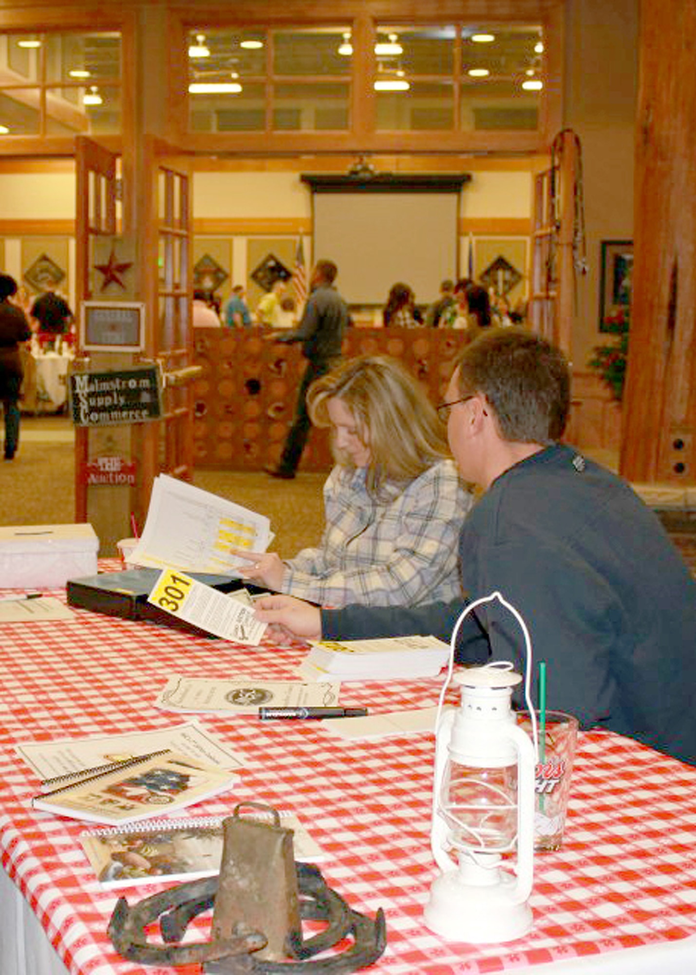 Two volunteers from the Malmstrom Spouses Club sign in attendees to Malmstrom’s 24th Annual Mercantile Auction on Nov. 17.  While there, attendees were able to enjoy a barbecue dinner and browse items available to bid on.  (U.S. Air Force Courtesy Photo)