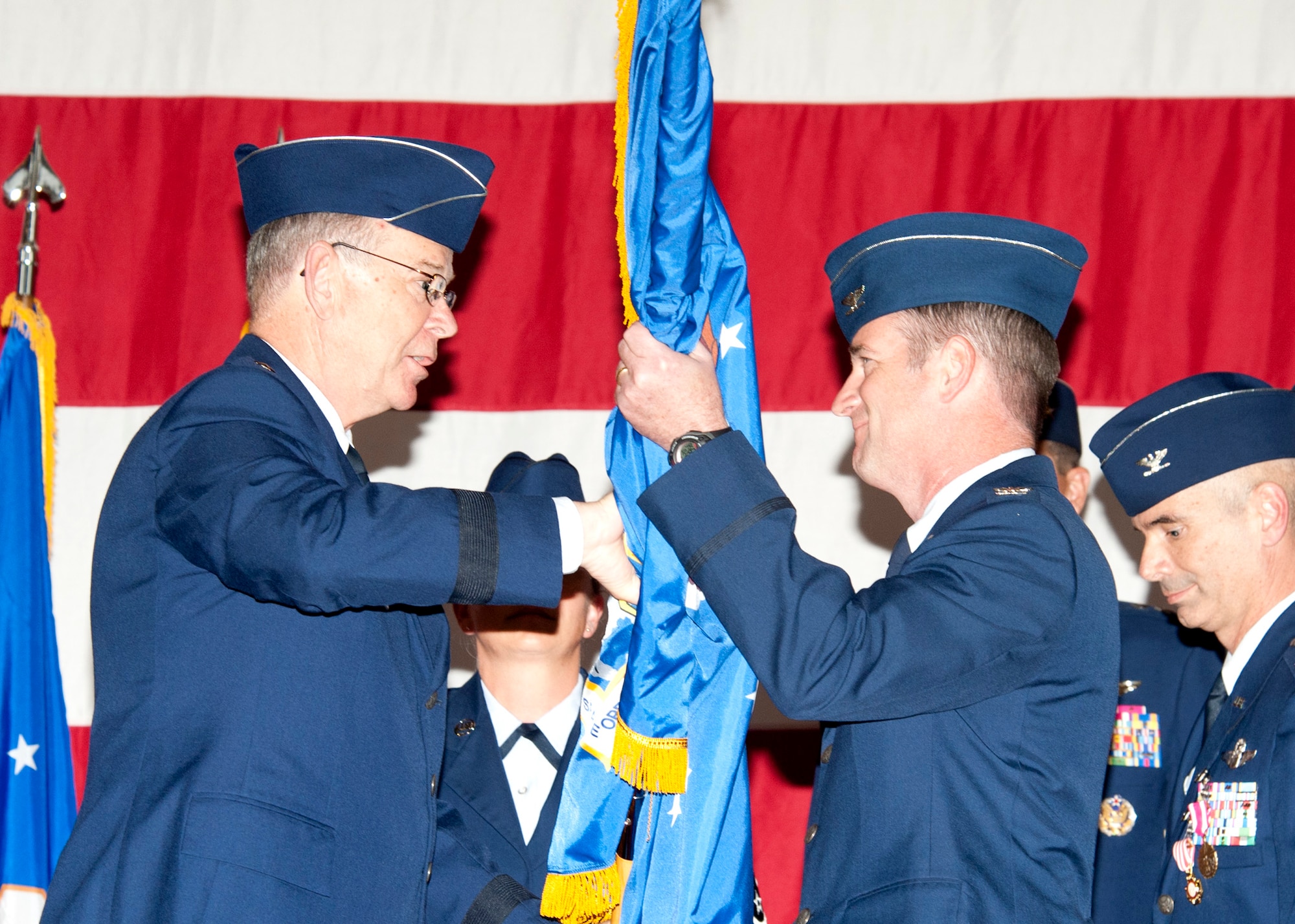U.S. Air Force Maj. Gen. Emmett  R. Titshaw Jr., left, Adjutant General of Florida, passes the 101st Air and Space Operations Group (101st AOG) flag to Col. John Ferry during a change of command ceremony held here Nov. 20, 2012. The 101st AOG was officially activated July 1, 2009. (U.S. Air Force photo by Lisa Norman/Released)