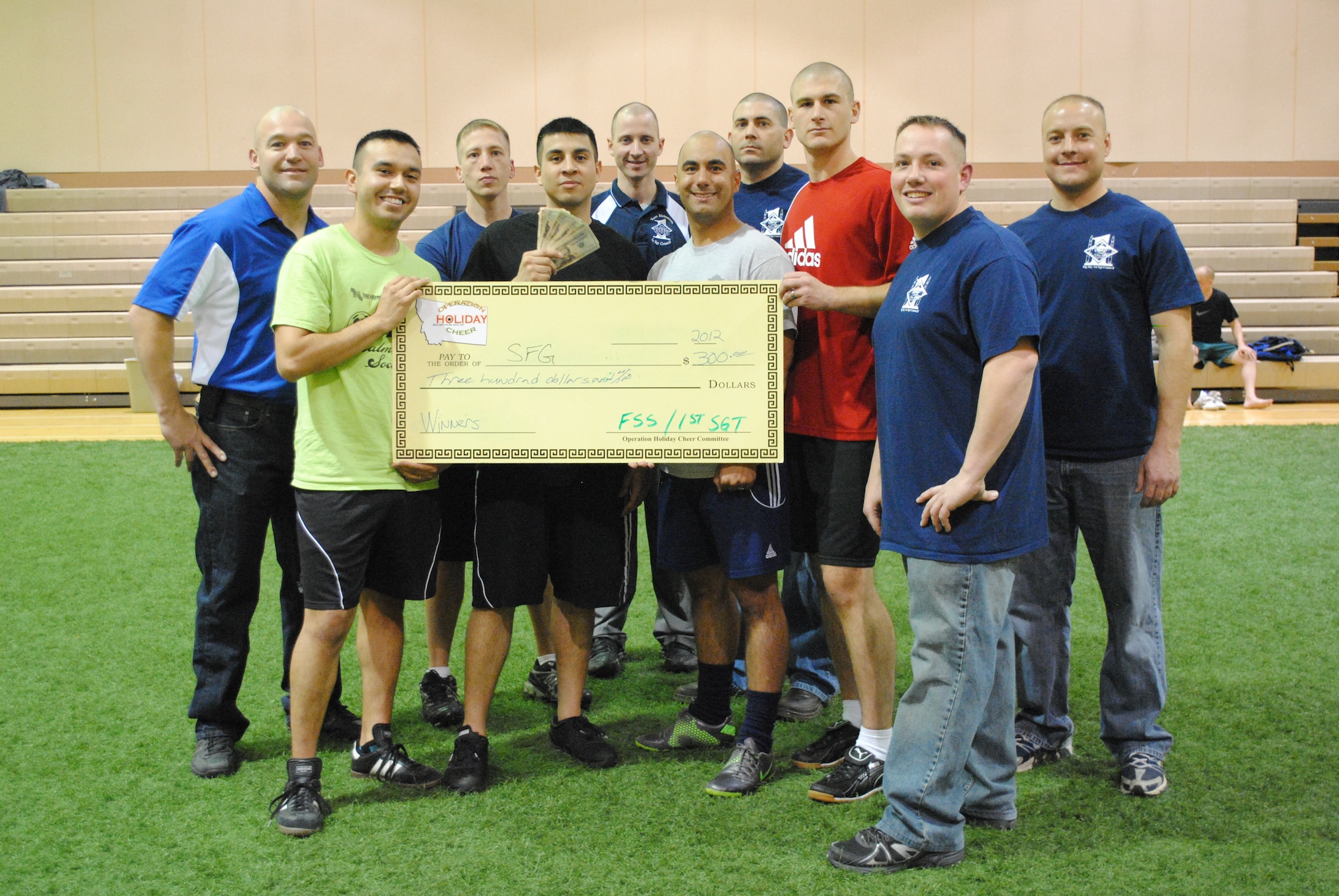 Members of the 341st Security Forces Group (center) pose with their $300 first-place prize for winning the soccer tournament on Nov. 16, the second of four events for this year’s Operation Holiday Cheer. Pictured from left to right are Master Sgt. James Thoma, 341st Maintenance Operations Squadron; Staff Sgt. Jaime Gutierrez, 341st Security Forces Squadron; Master Sgt. Jeremiah Martin, 341st Operations Group; Staff Sgt. Steffen Lopez, 741st Missile Security Forces Squadron; Master Sgt. Bradley Thye, 341st Logistics Readiness Squadron; 1st Lt. Joel Lobisser, 741st MSFS; Master Sgt. Kirk McManious, 341st Force Support Squadron; Master Sgt. Eric Rethage, 341st SFS; Master Sgt. Colin Crandall, 341st Medical Group; and Master Sgt. William Baccus, 341st Civil Engineer Squadron. The next event is a 9-pin, no tap bowling tournament scheduled for today from 5 to 8 p.m., followed by a scavenger hunt scheduled for today until Dec. 2. For more information or to sign-up, go to www.341fss.com. (U.S. Air Force photo/Airman 1st Class Katrina Heikkinen)
