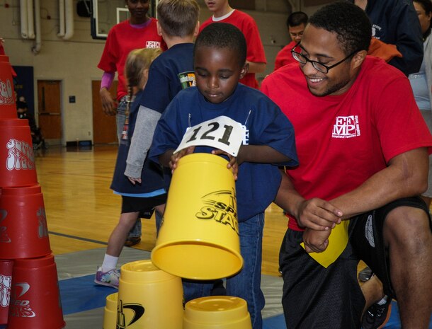 Malik Rock plays a game of stack the cups with Airman 1st Class Gardy Banks, 437th Aircraft Maintenance Squadron, Nov. 17, 2012, during the Special Olympics Event at the Joint Base Charleston – Air Base Fitness Center, S.C. The event provided Exceptional Family Member Program  members the opportunity to develop physical fitness skills and make connections with other children. Banks volunteered to be Rock’s ‘buddy’ and escorted him through the various challenges. (U.S. Air Force photo / 1st Lt. Jennifer Swann)