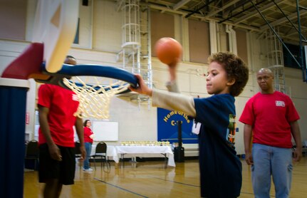 (Right) Master Sgt. Jason Broadus, 437th Airlift Wing Maintenance Squadron resource advisor, watches his seven-year- old son, Alexander Broadus, dunk a ball into a basketball hoop during the Joint Base Charleston Exceptional Family Member Program’s Special Olympics Event Nov. 17, 2012, at the JB Charleston – Air Base Fitness Center, S.C. (U.S. Air Force photo / Airman 1st Class Tom Brading)