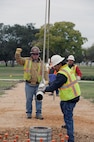 Steven Knight(left) gives directions to a crane operator, while Ricardo Muniz and Bruce Real position the POW/MIA flag pole for installation Nov. 13 at Joint Base San Antonio-Randolph Airmen's Heritage Park. (U.S. Air Force photo by Don Lindsey)